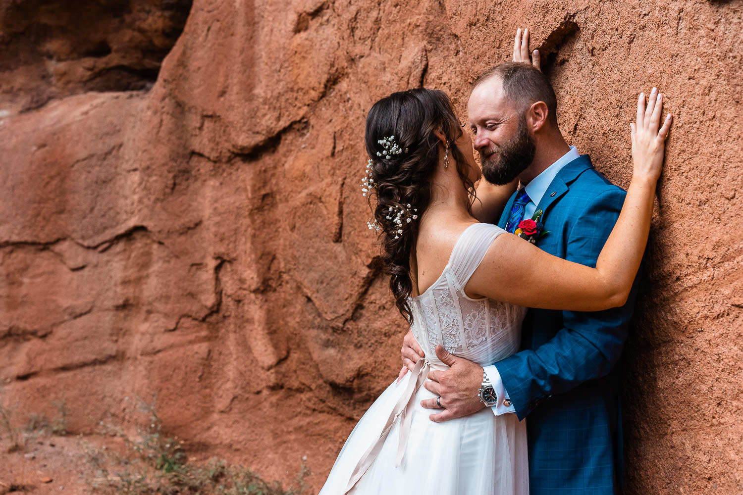 newlyweds snuggle against Colorado red rocks