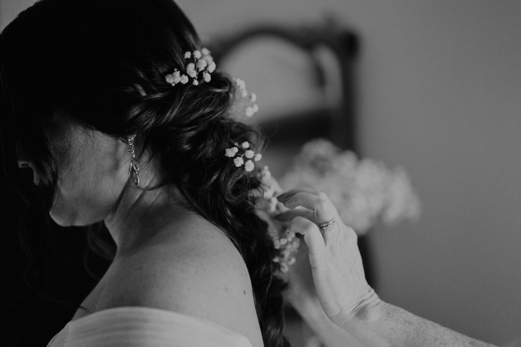 bride gets her hair done by a hairstylist