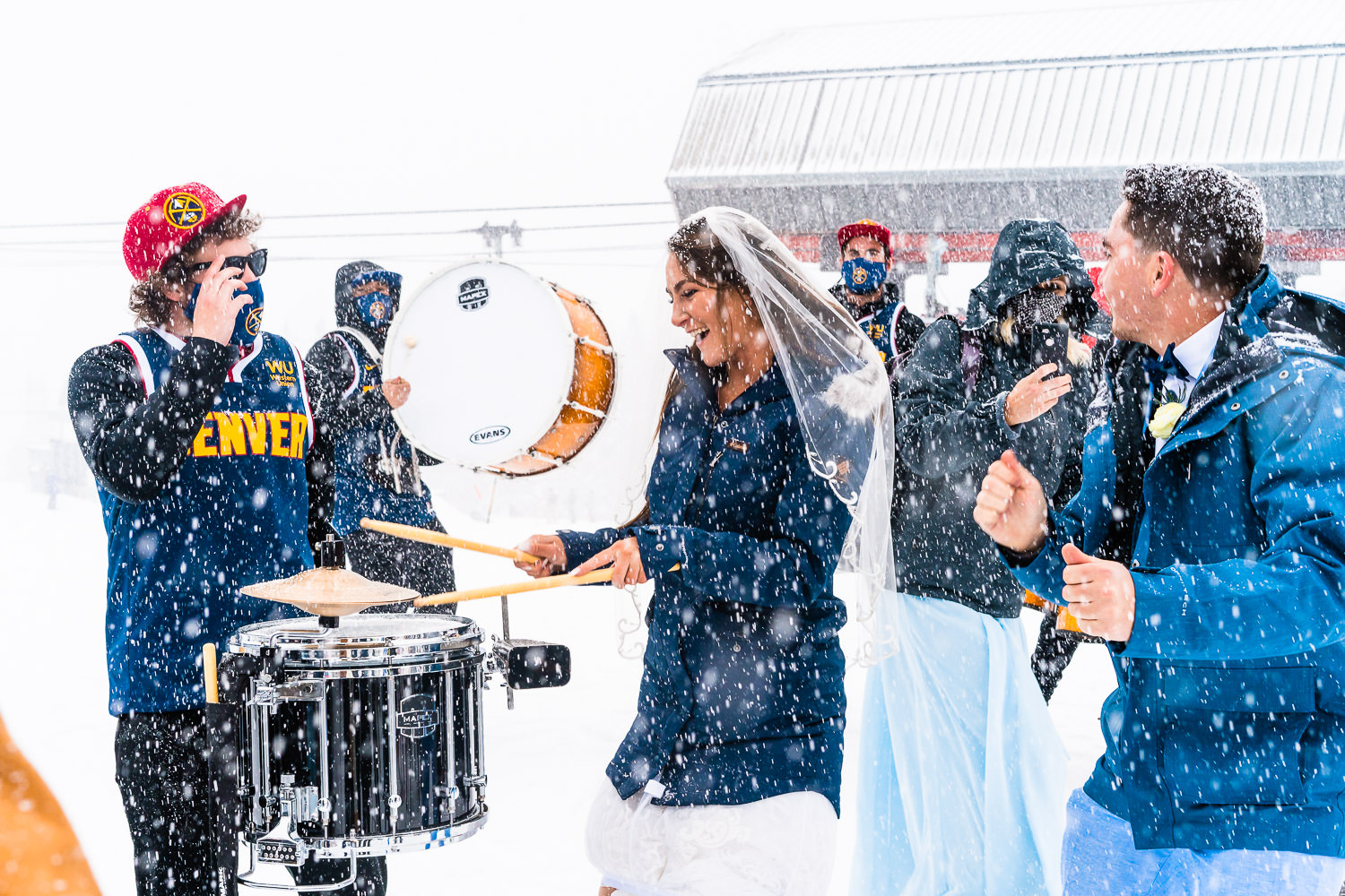 Bride playing drums in a snowstorm