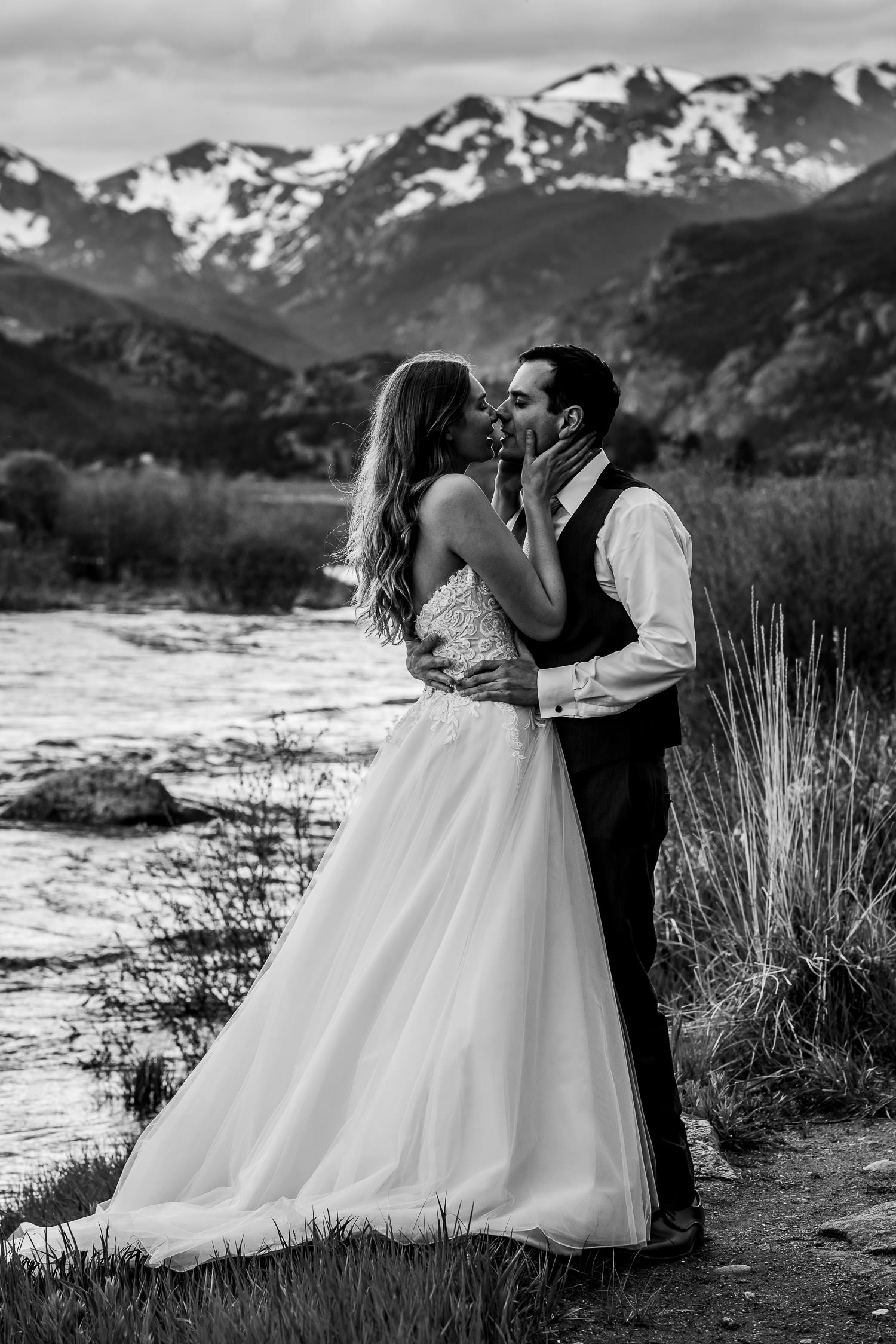 Newlyweds near a stream in the mountains