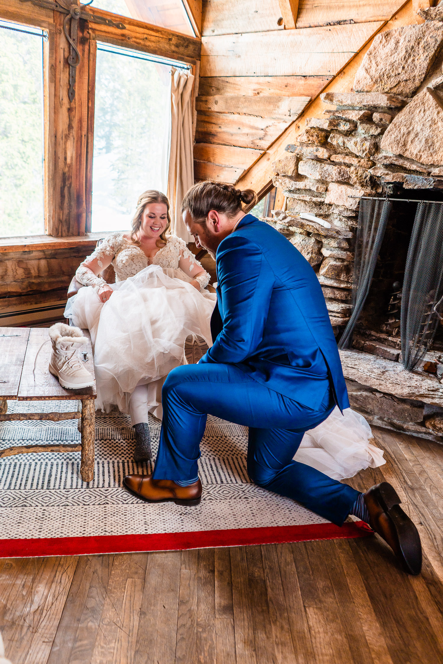 groom putting on his bride's shoes
