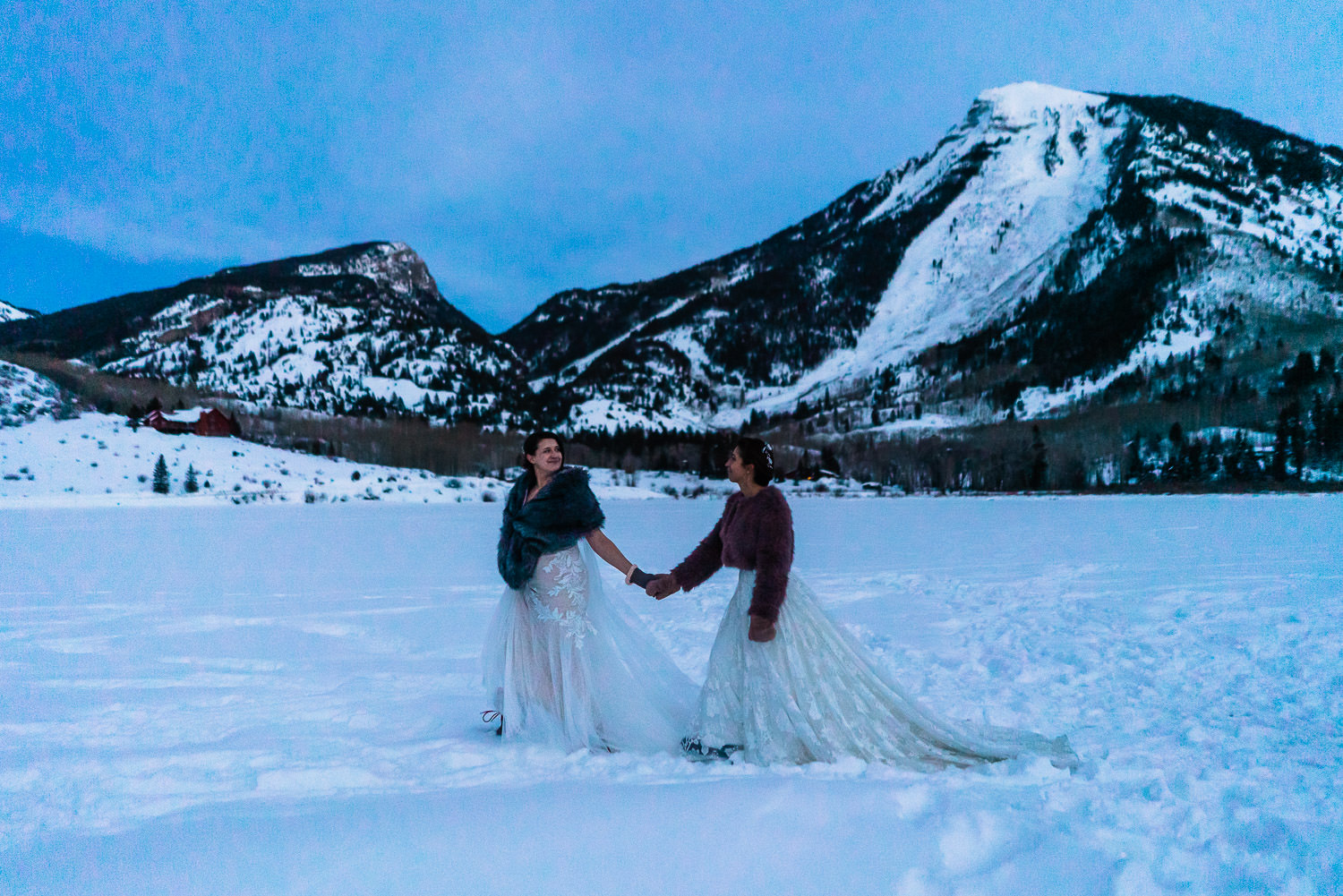 newlywed brides walking over a frozen and snowy lake