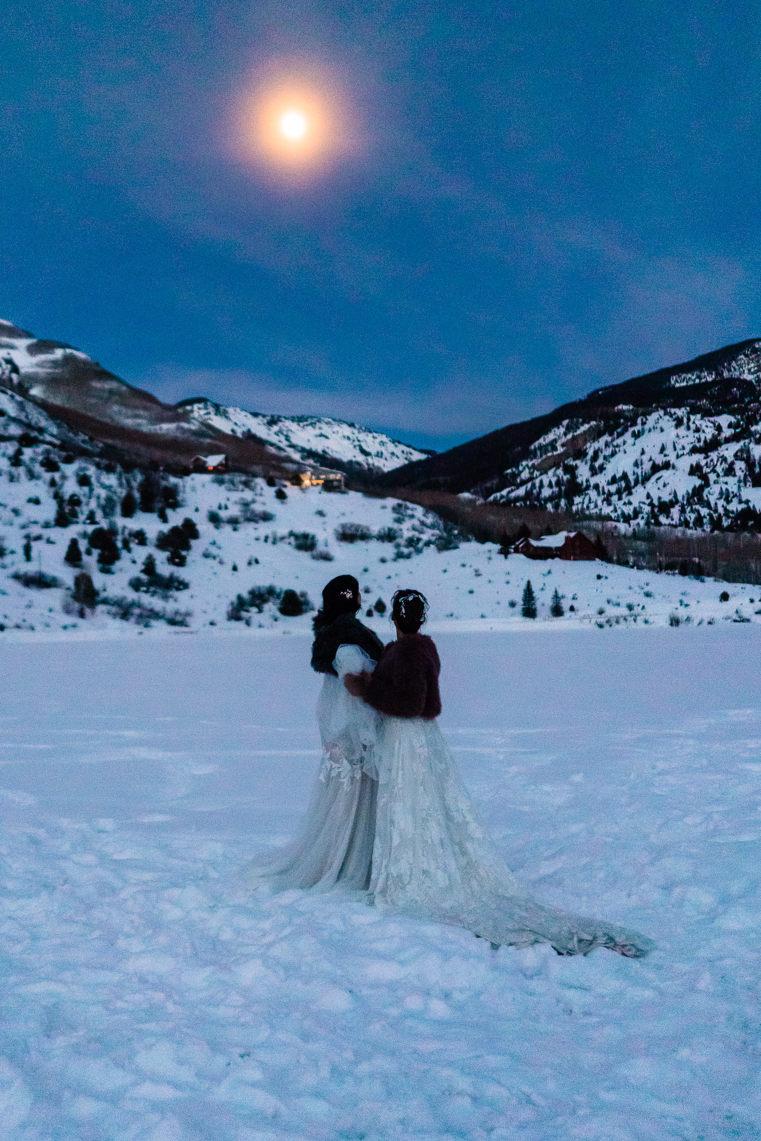 two newlywed brides beneath a full moon after their LGBTQ+ Elopement