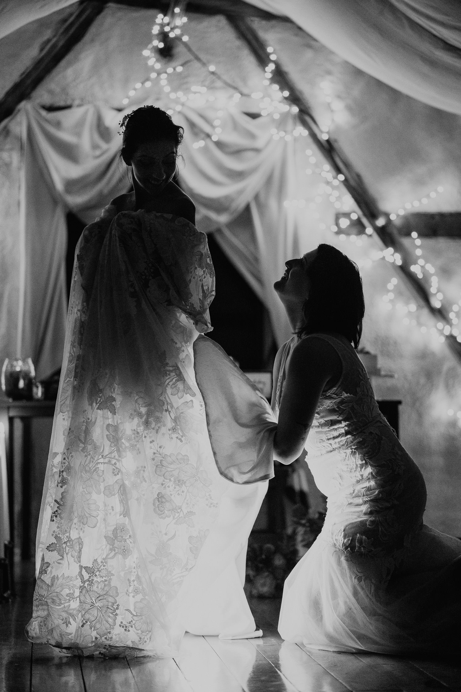 bride helping her partner bustle her dress