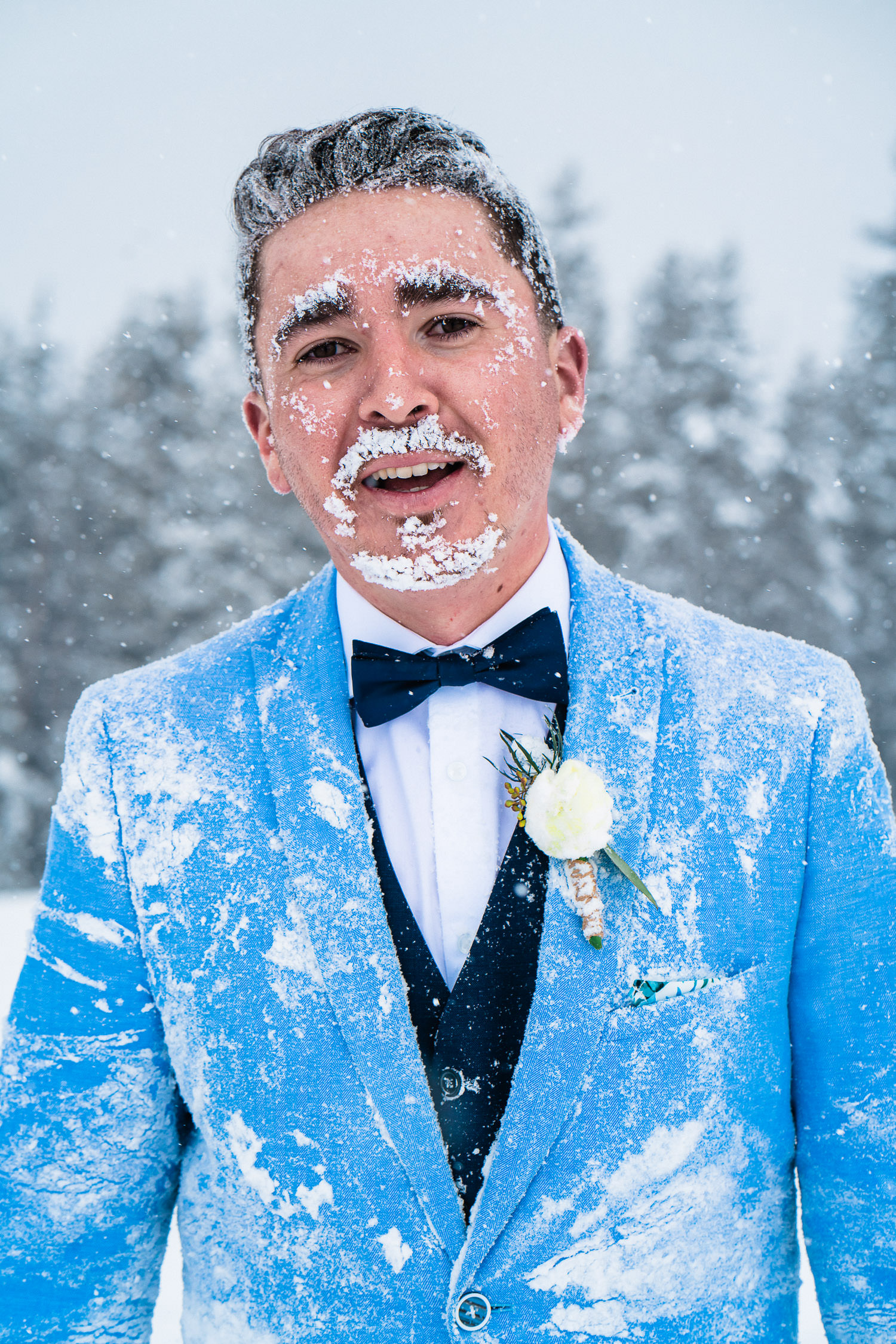 Groom covered in snow during his elopement