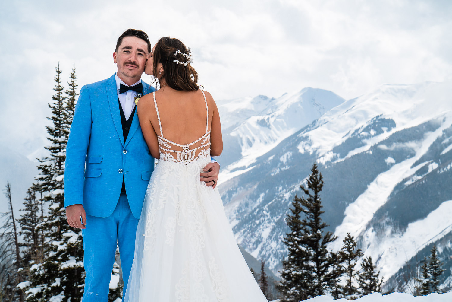 newlyweds embrace on the top of Aspen Mountain during their Colorado Winter elopement