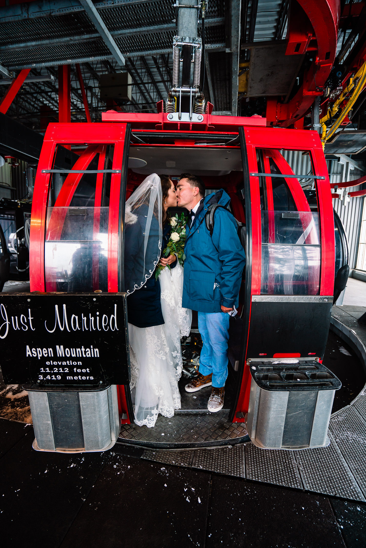 newlyweds kissing on a ski lift during their Colorado winter elopement