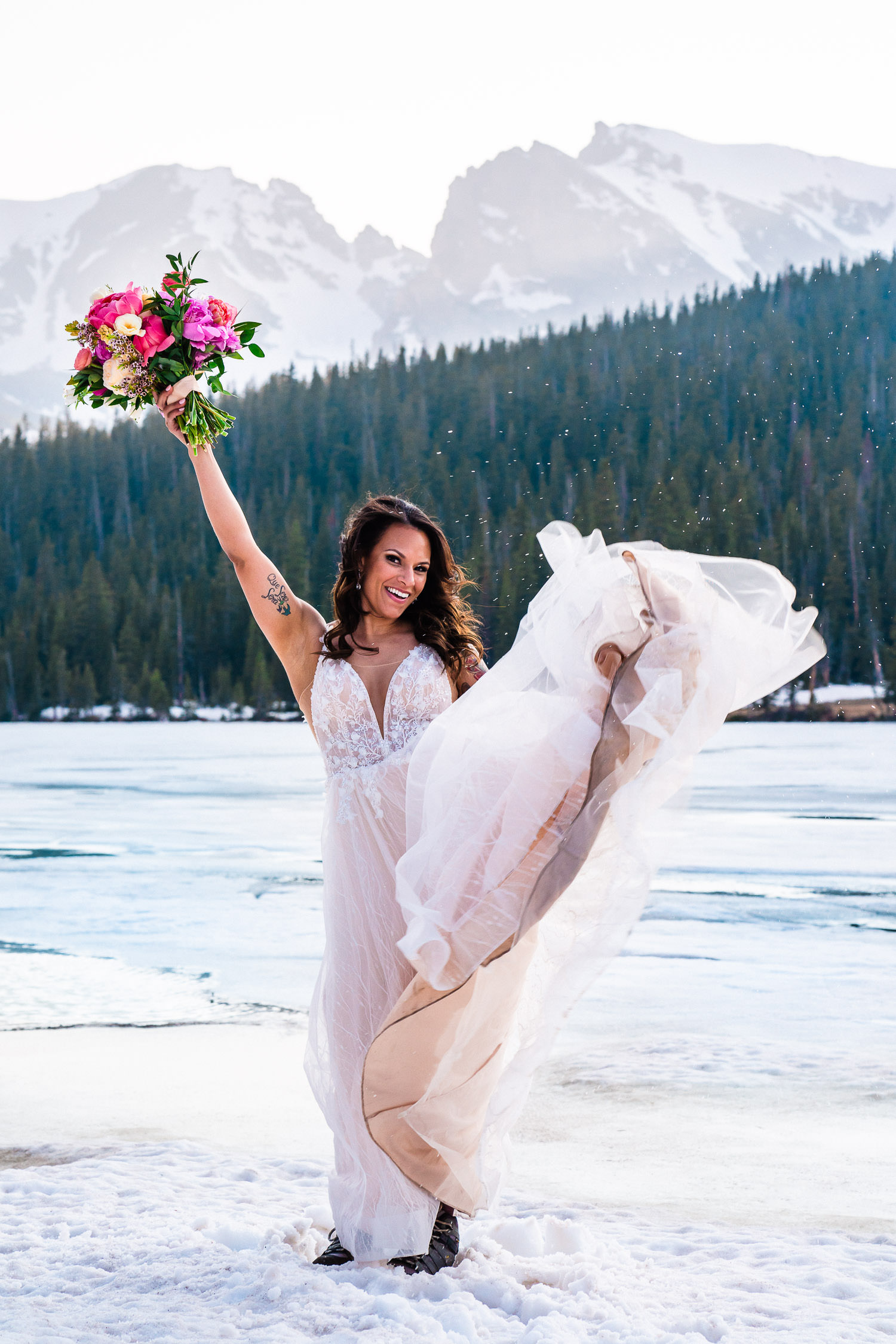 bride celebrates her marriage during her snowy Colorado winter elopement