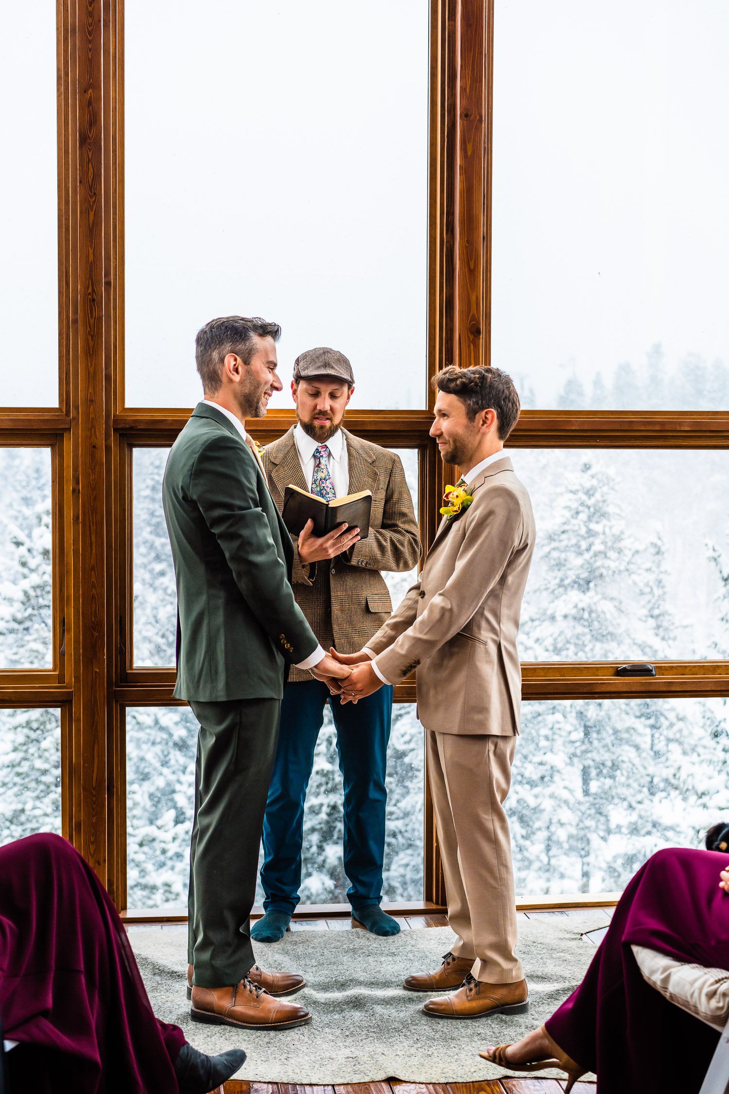 grooms exchange vows indoors during their Colorado winter elopement