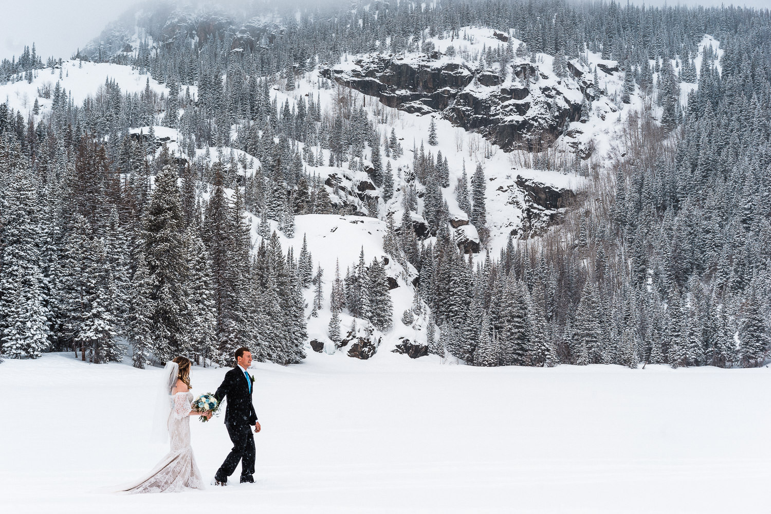 couple walking on a frozen lake during their winter elopement