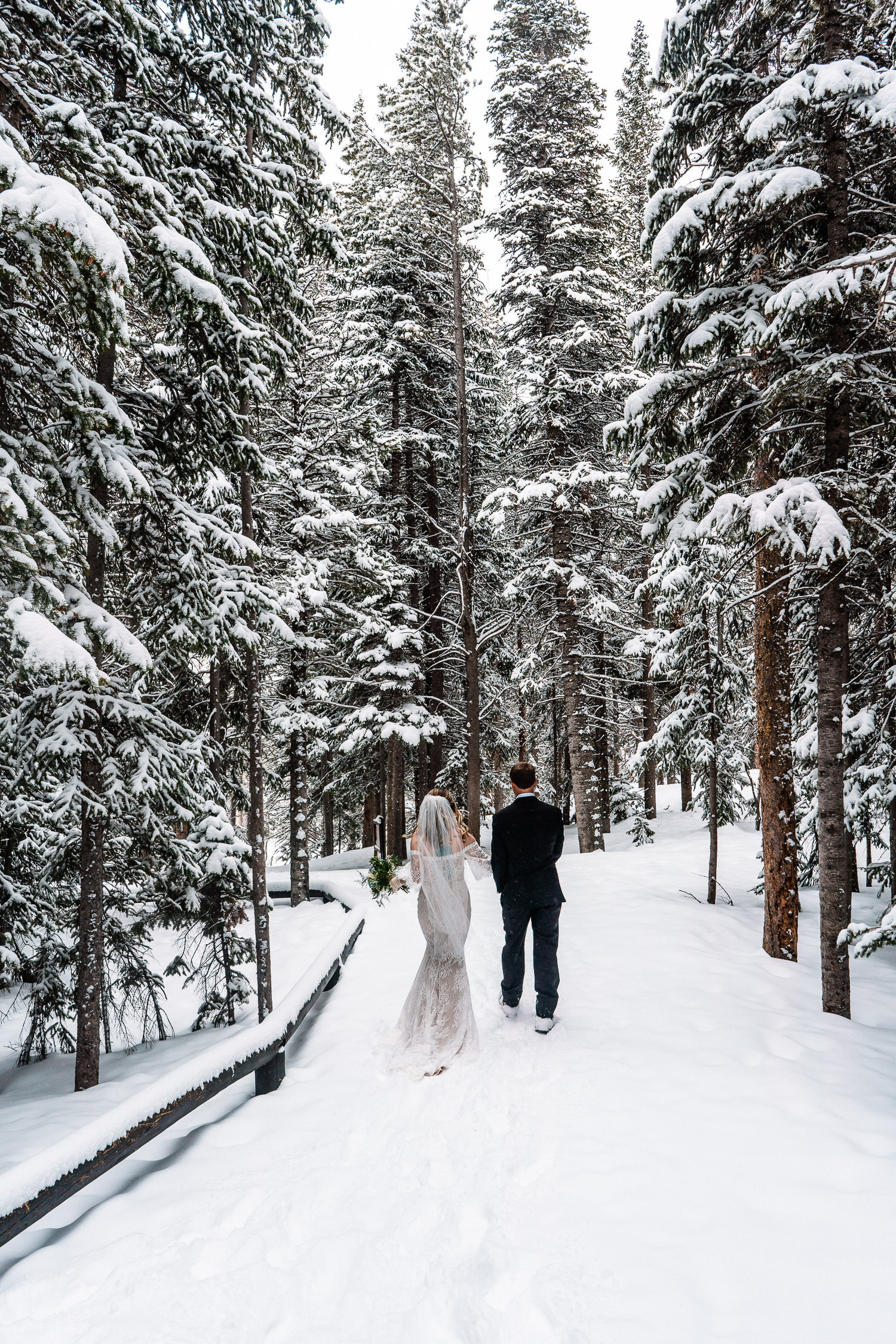 newlyweds exploring a winter trail during their snowy Colorado elopement