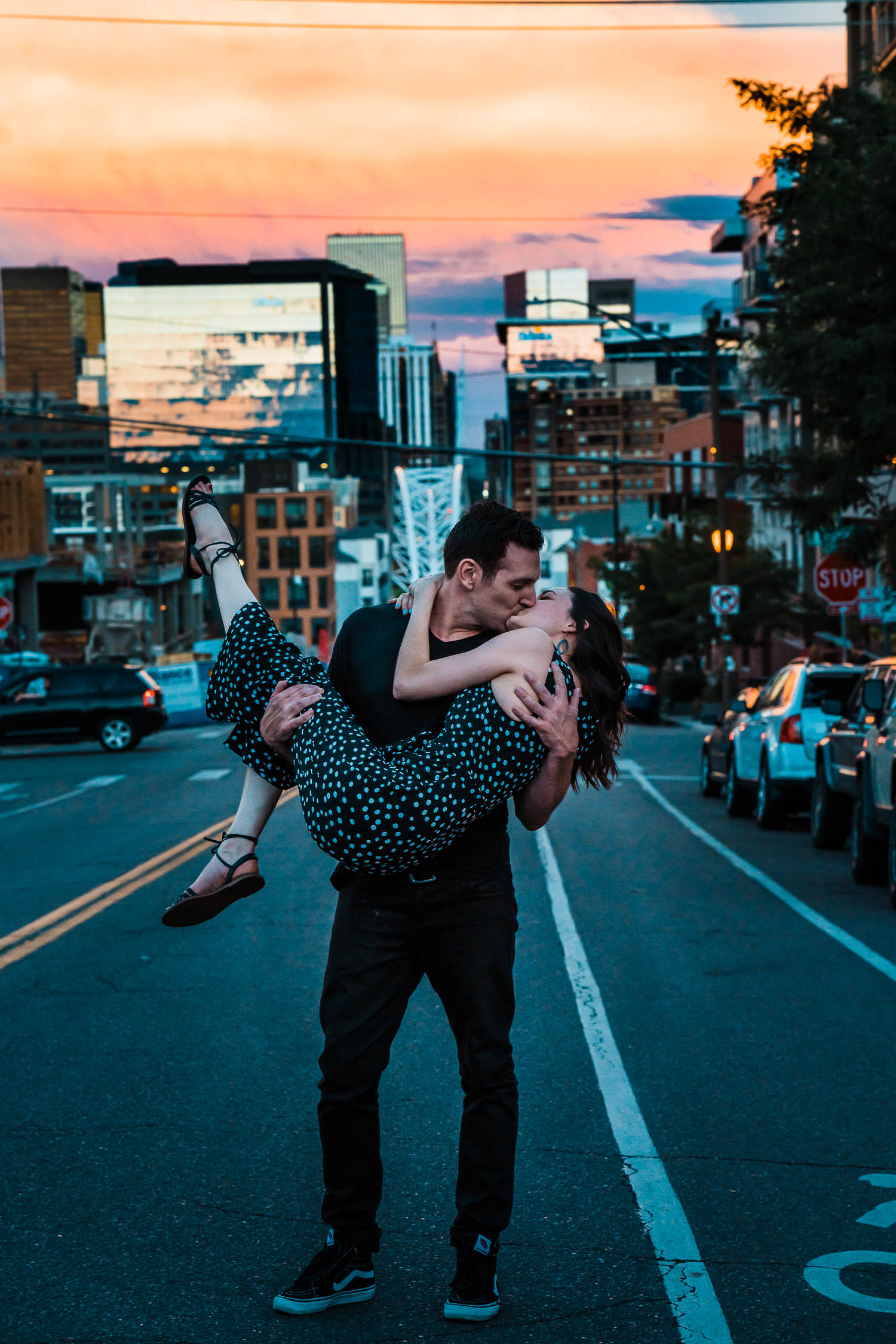 Couple kissing at sunset overlooking Denver skyline
