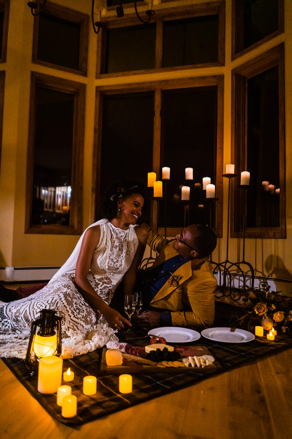 bride and groom dine by candle light at their airbnb in Colorado during their elopement