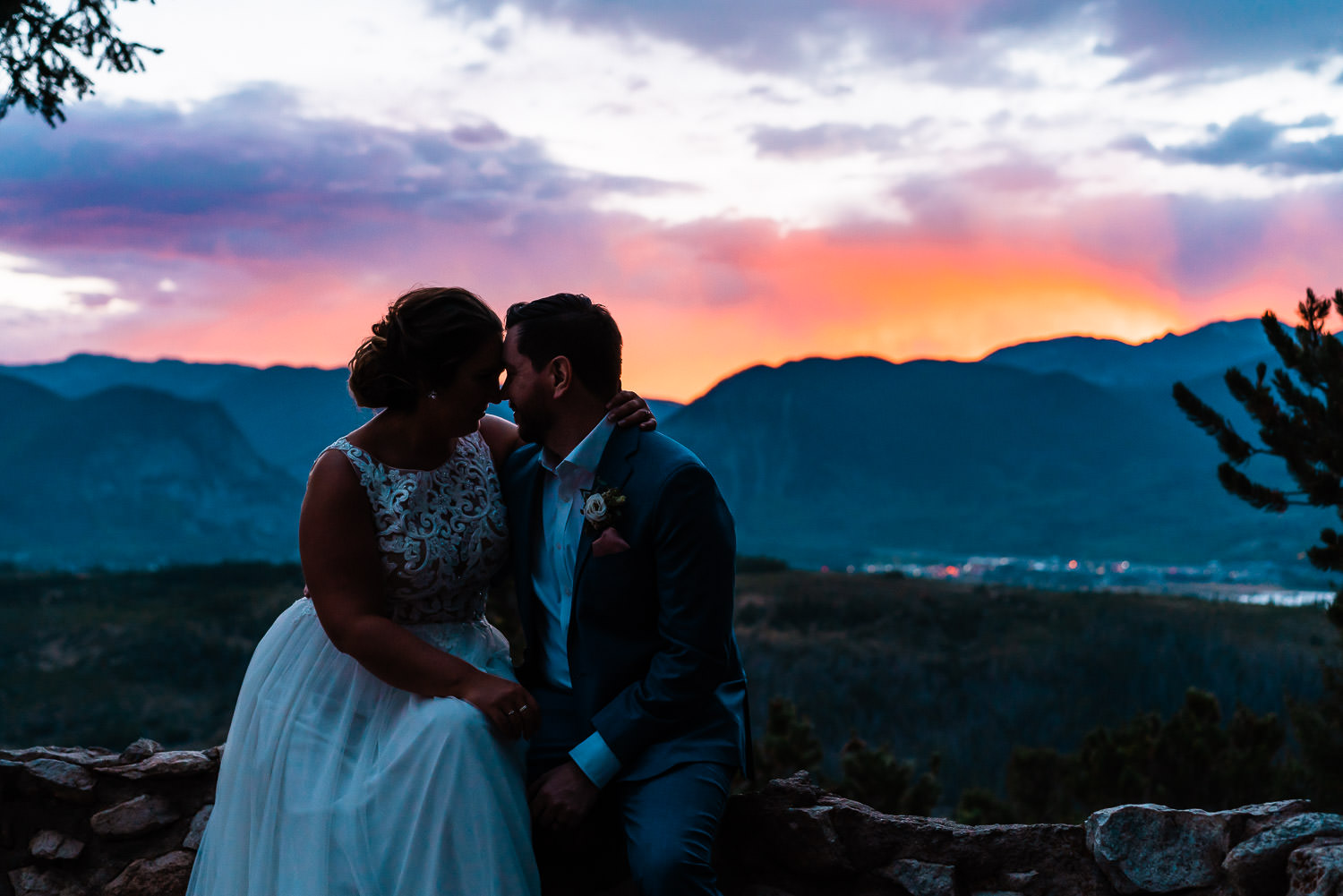 Bride and groom cuddling as the sunsets over the mountains in Breckenridge Colorado