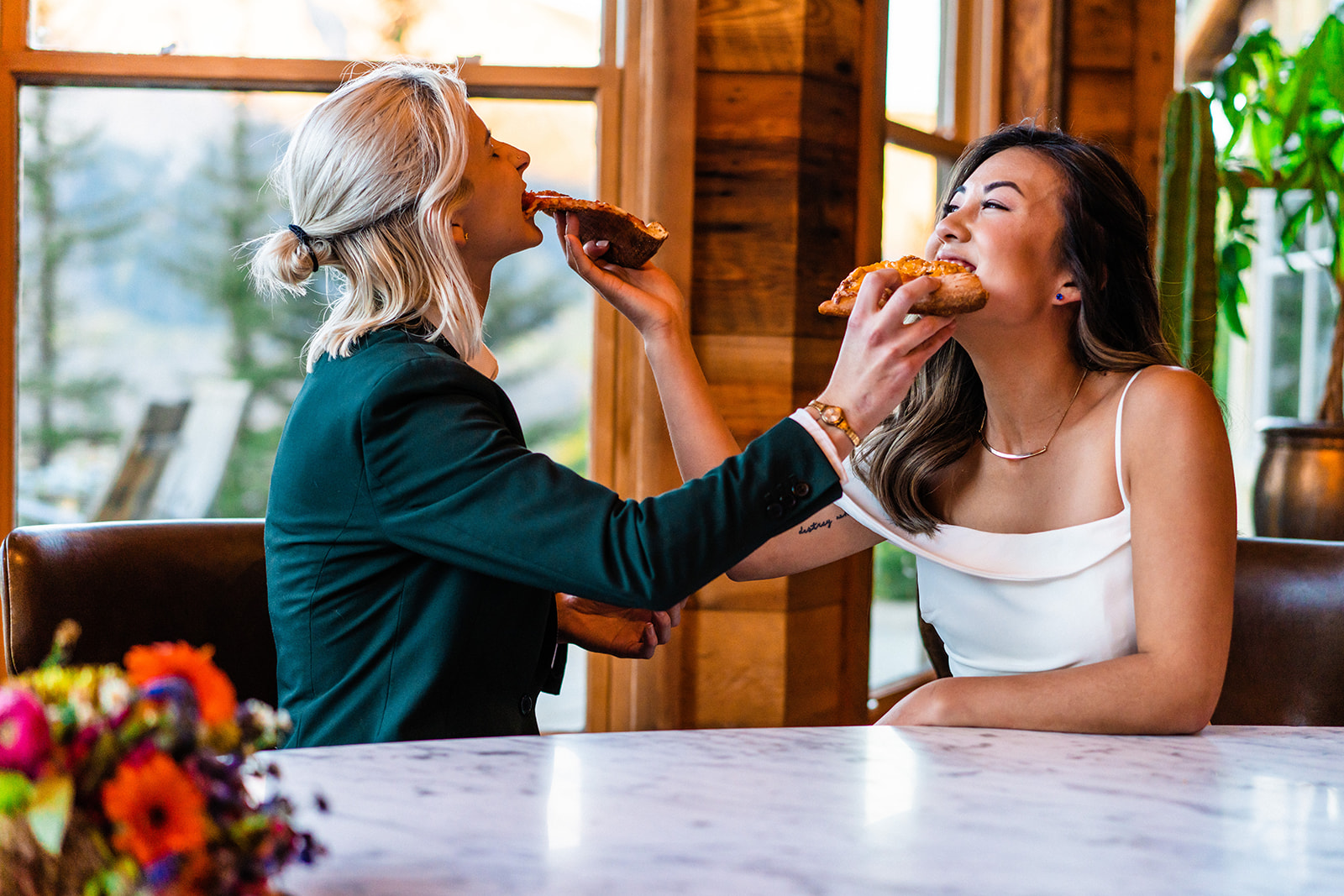 Lesbian Couple feeding eachother pizza on their elopement day