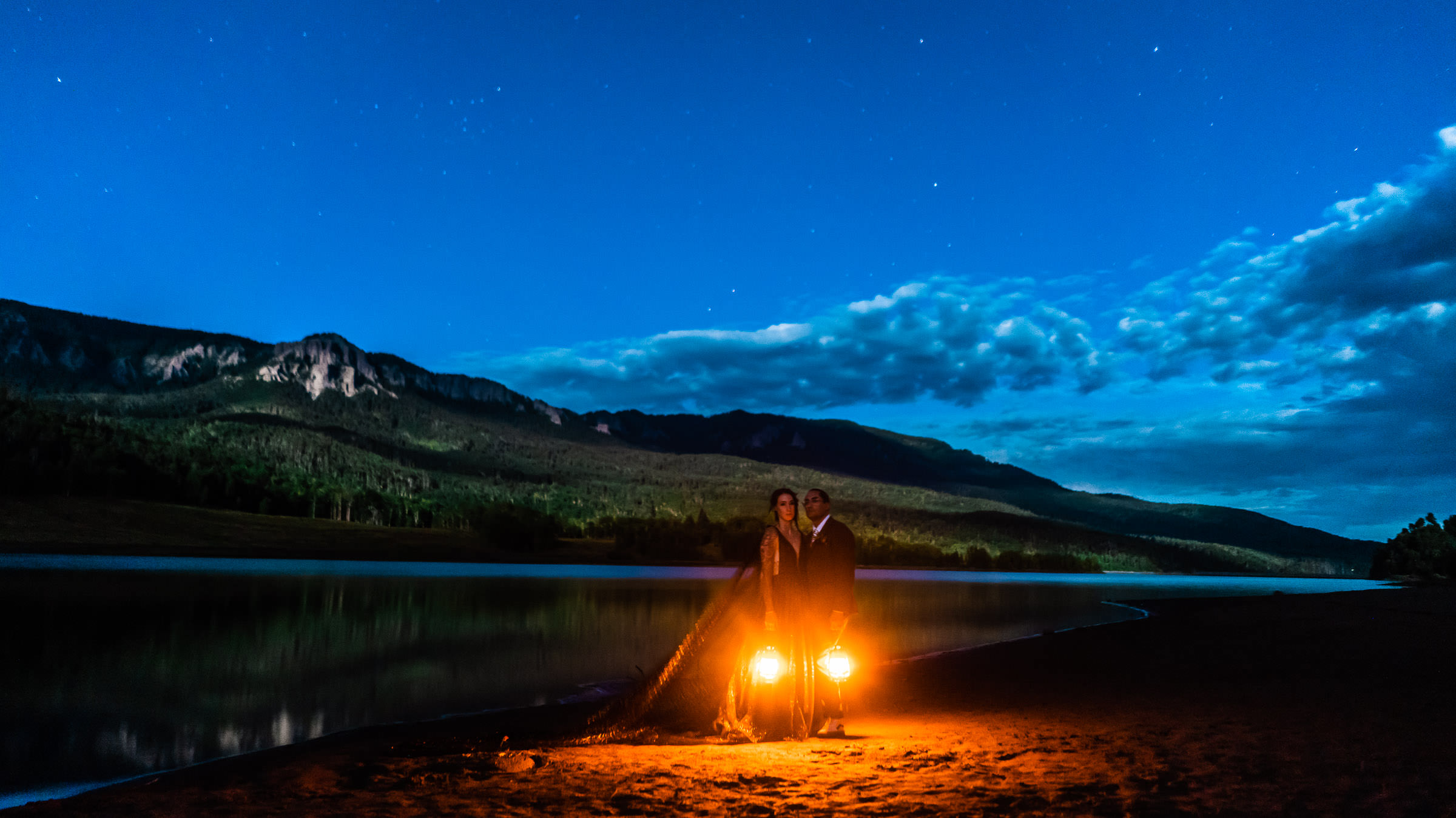 Bride and Groom watch full moon rise with lanterns under a starry sky