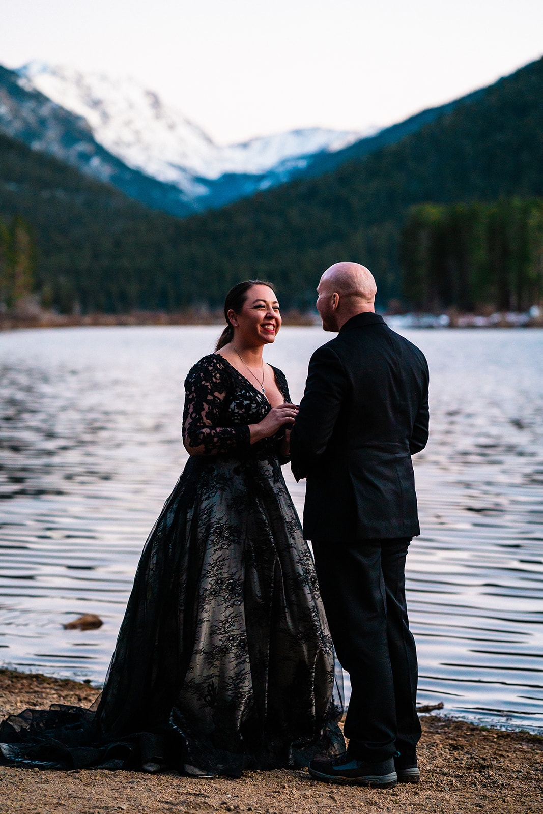 Beautiful bride and groom exchanging vows by a lake
