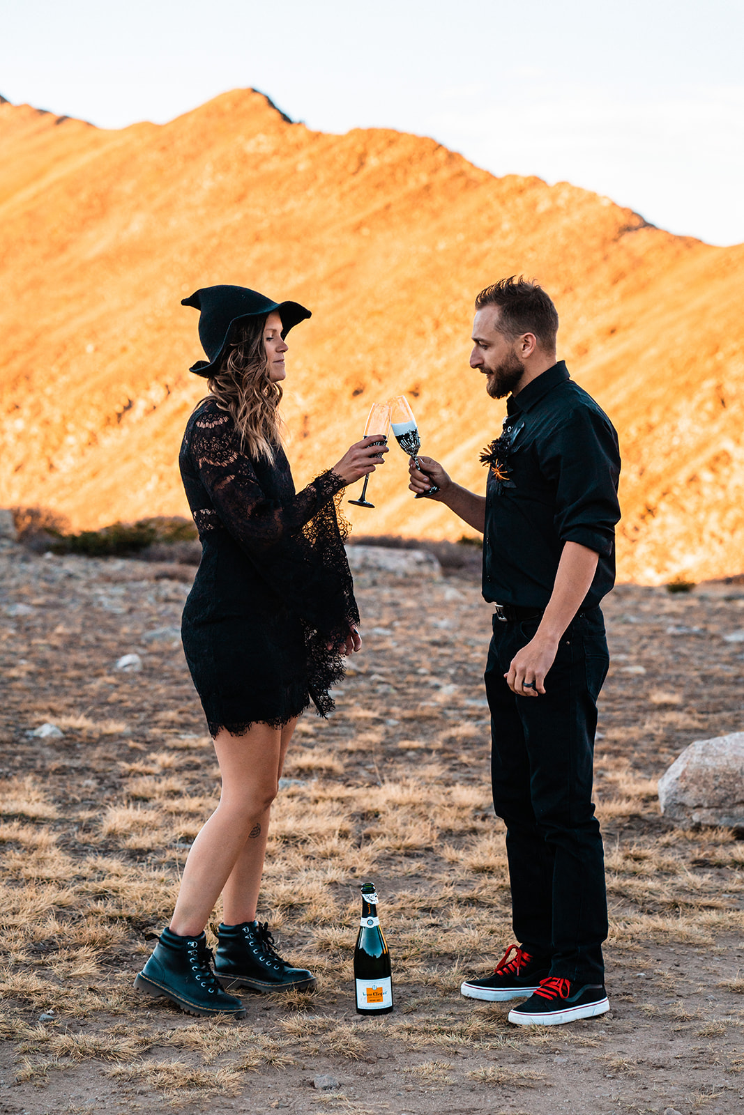Bride and groom toasting to their halloween elopement with Two spooky champagne glasses
