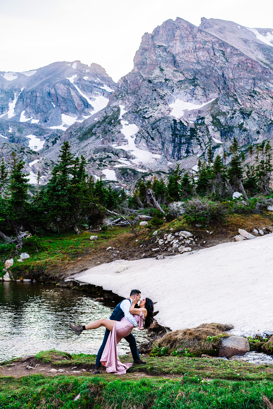 Bride and groom posing in front of Lake Isabelle