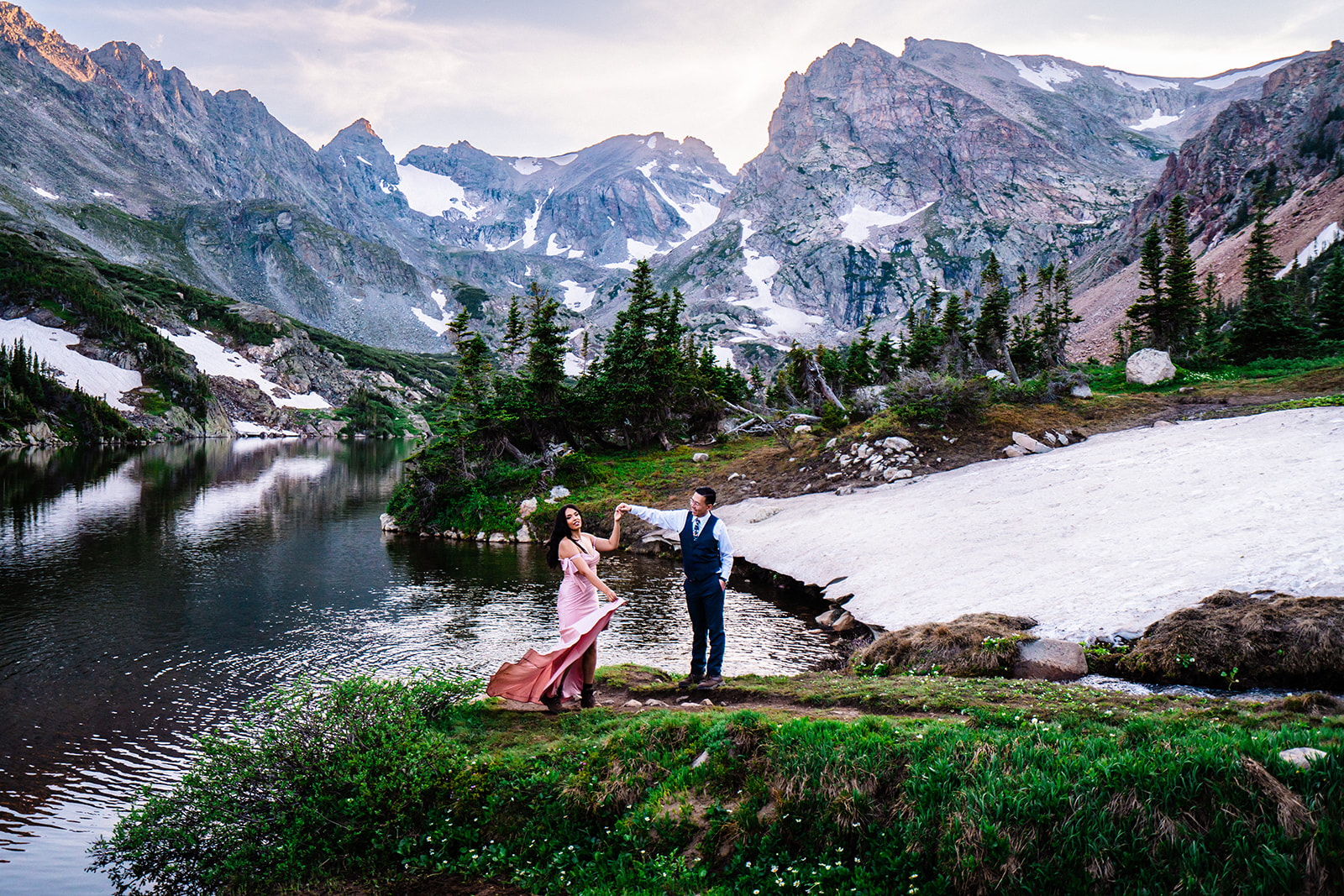 Bride and groom posing in front of Lake Isabelle