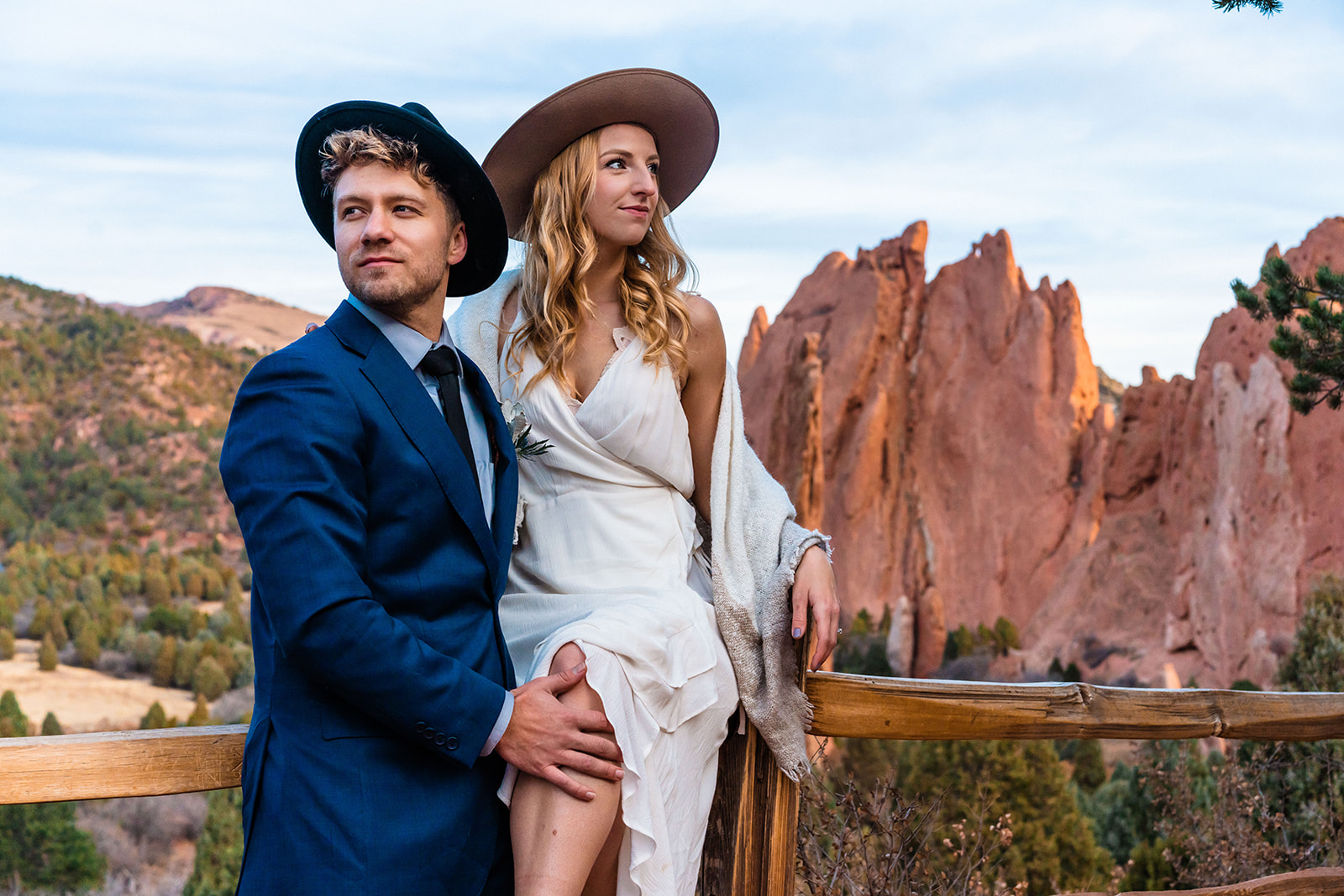Newly engaged couple sitting in front of bright red rocks at the Garden of the Gods
