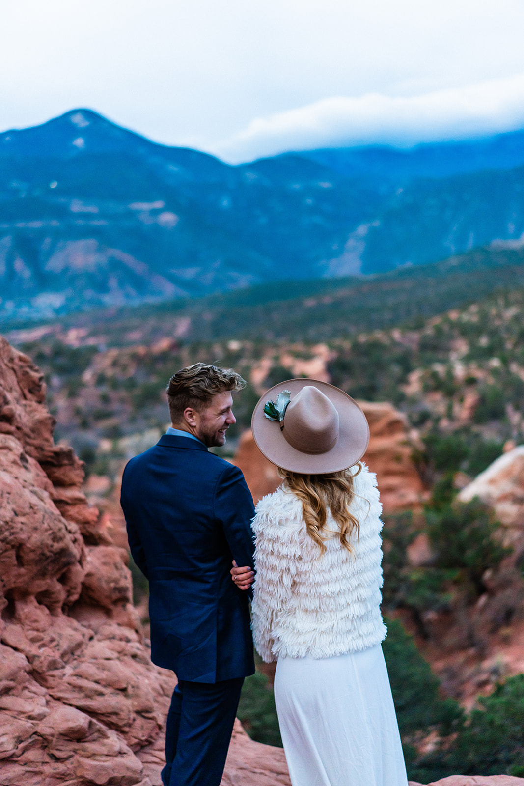 Adventurous engaged couple staring off into the distance at The Garden of the Gods in Colorado
