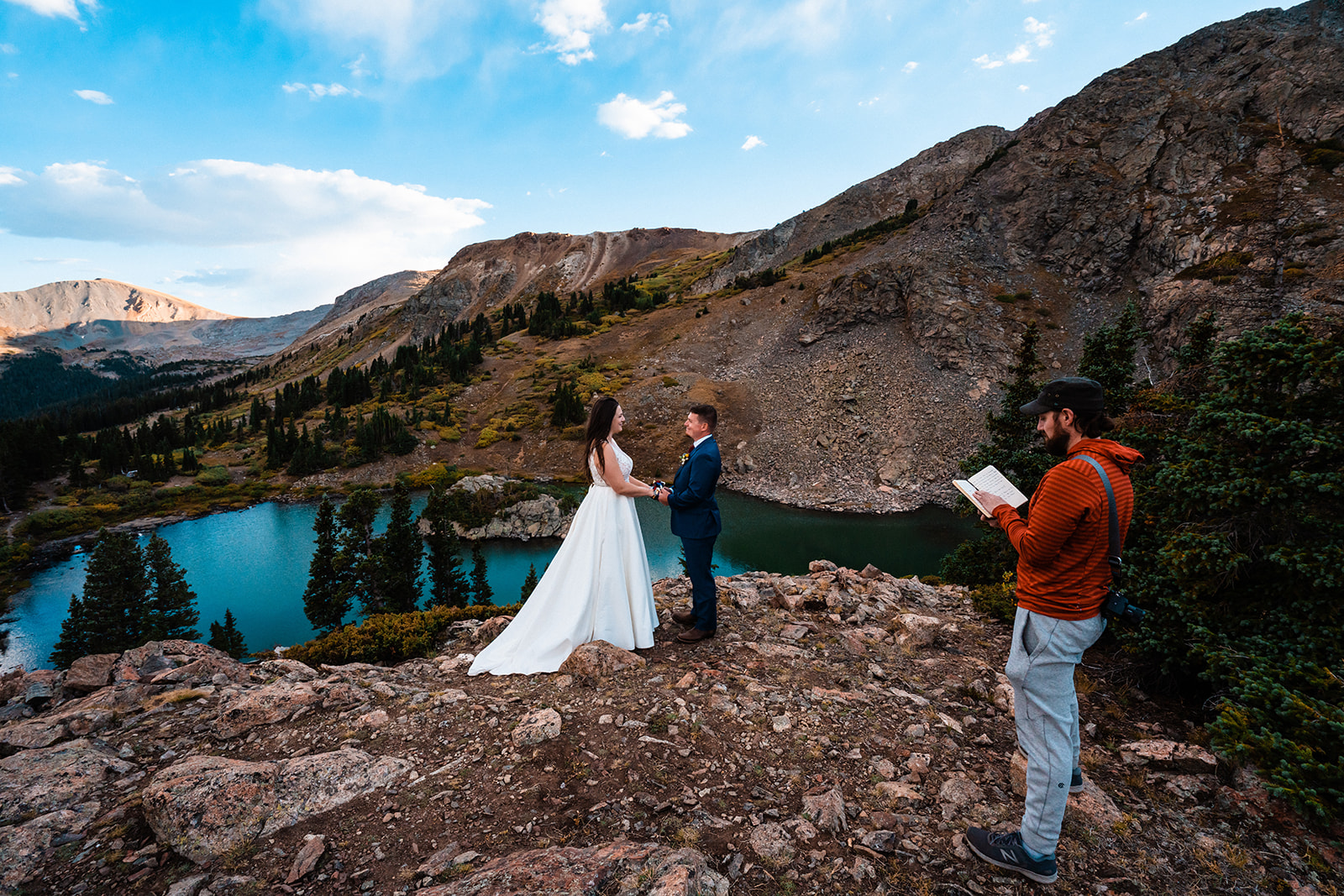 Bride and groom exchanging vows at alpine lake