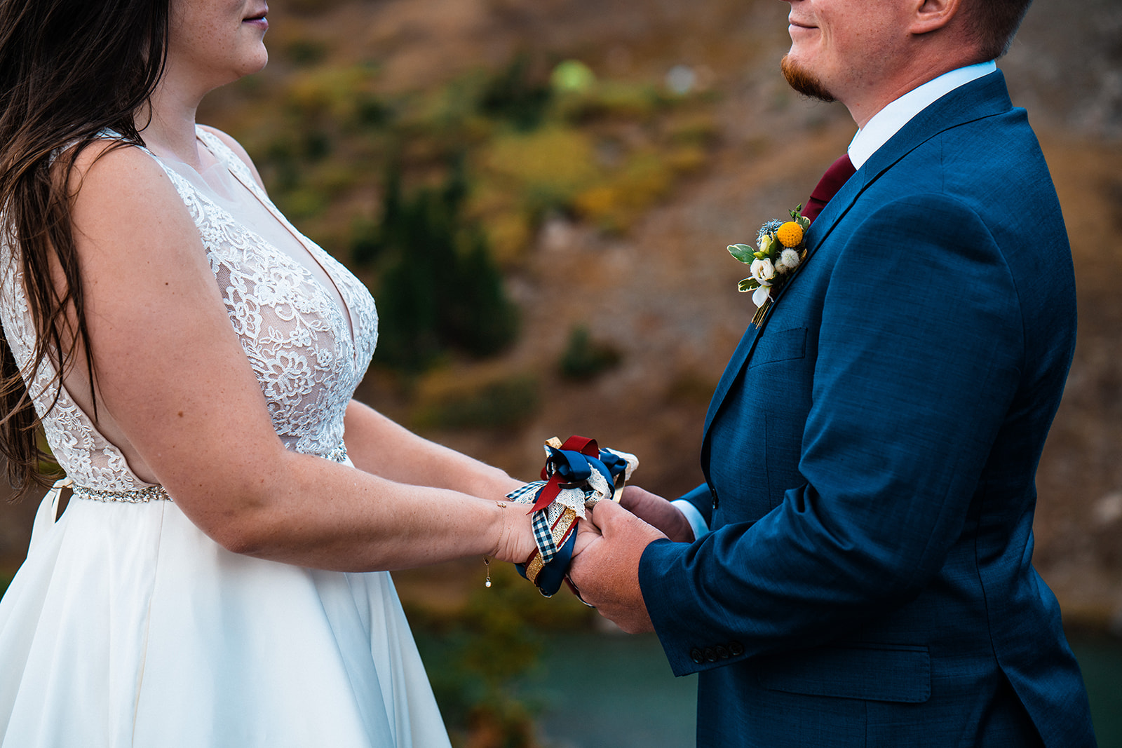 Bride and groom exchanging vows at alpine lake