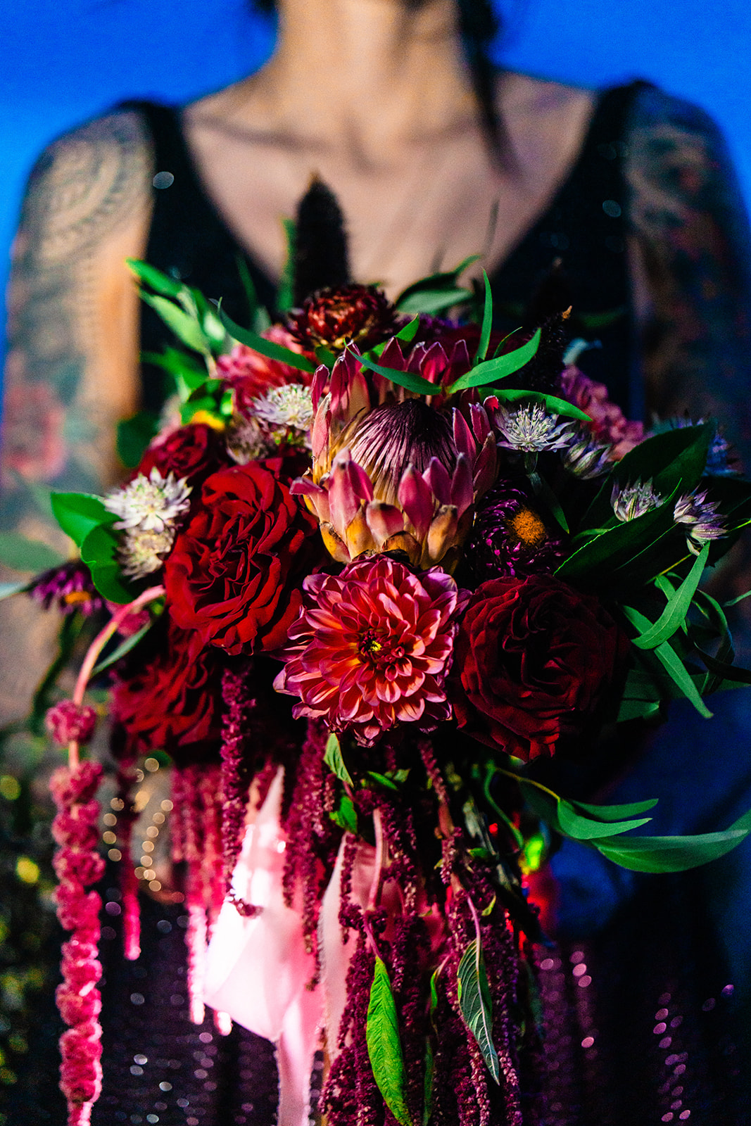 Beautiful bride holding a colorful bouquet full or red and pink florals