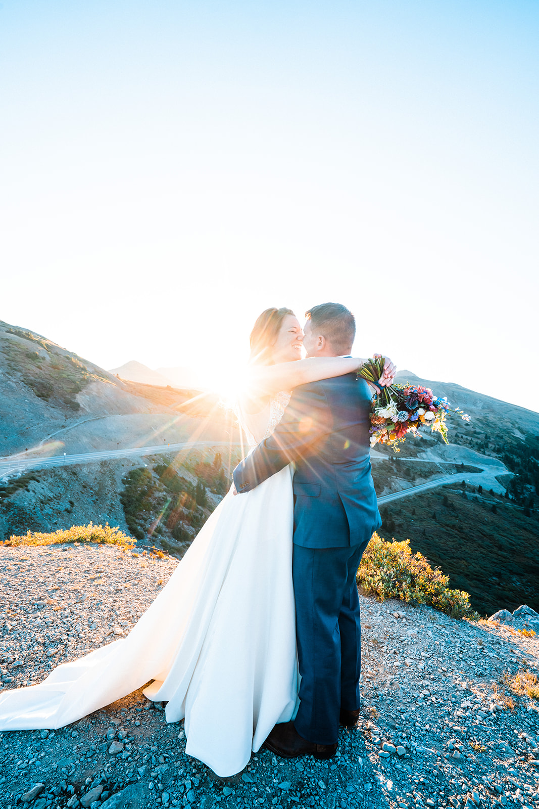 Bride and groom holding one another during sunset