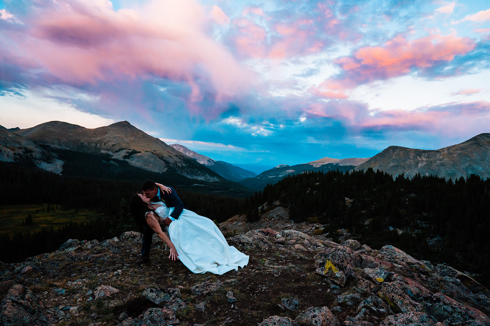 Groom dipping bride during sunset