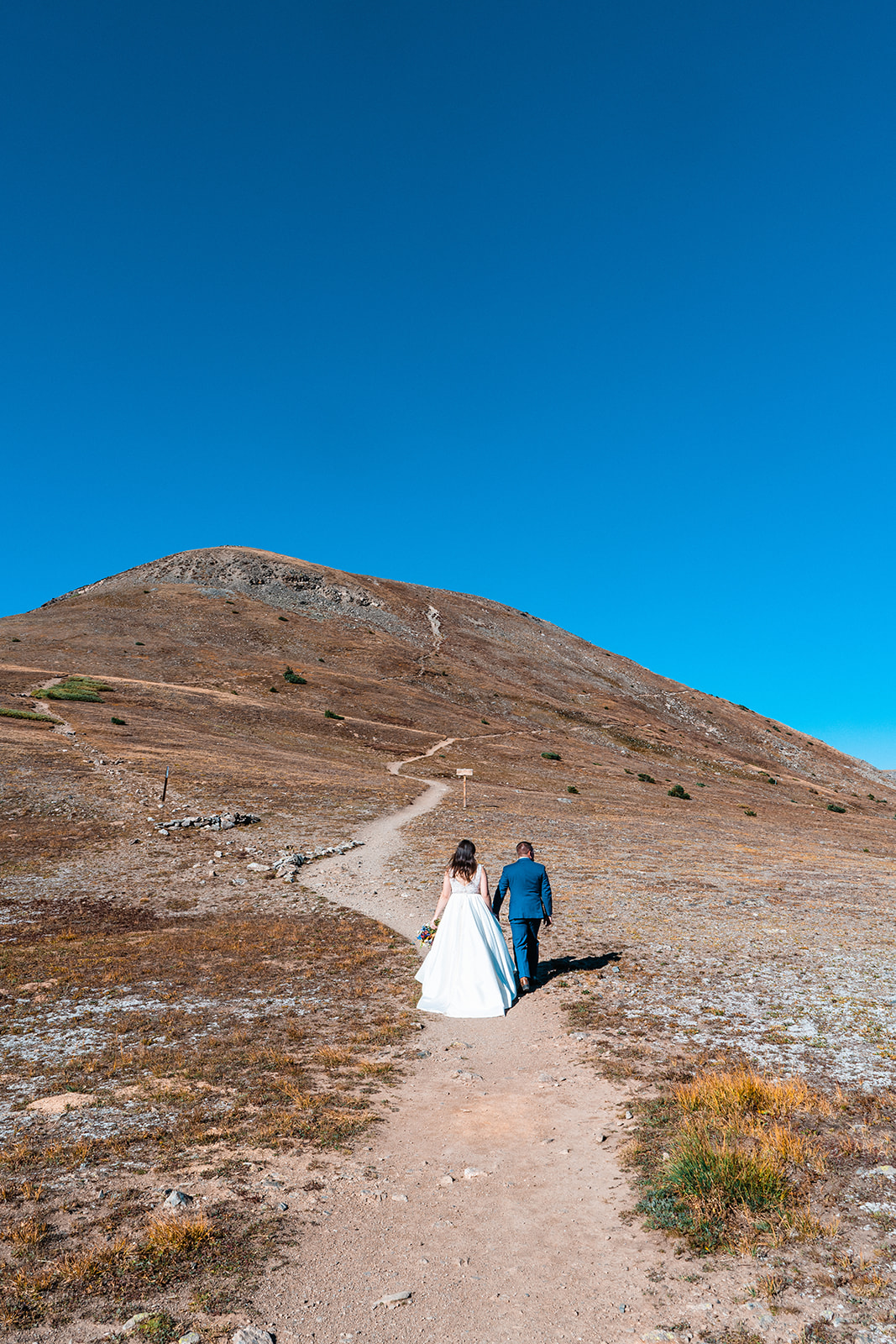 Bride and groom hiking up the Colorado mountains
