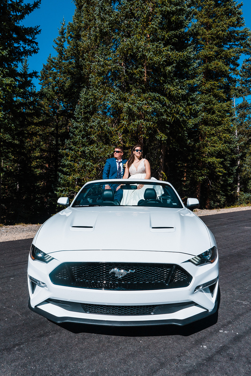 Bride and groom posing in a sports car