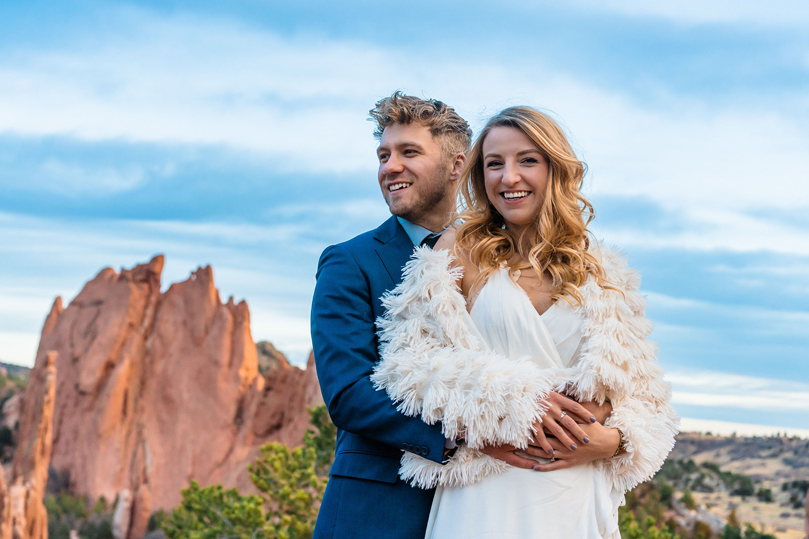 Engaged couple smiling and holding one another at the Garden of the Gods