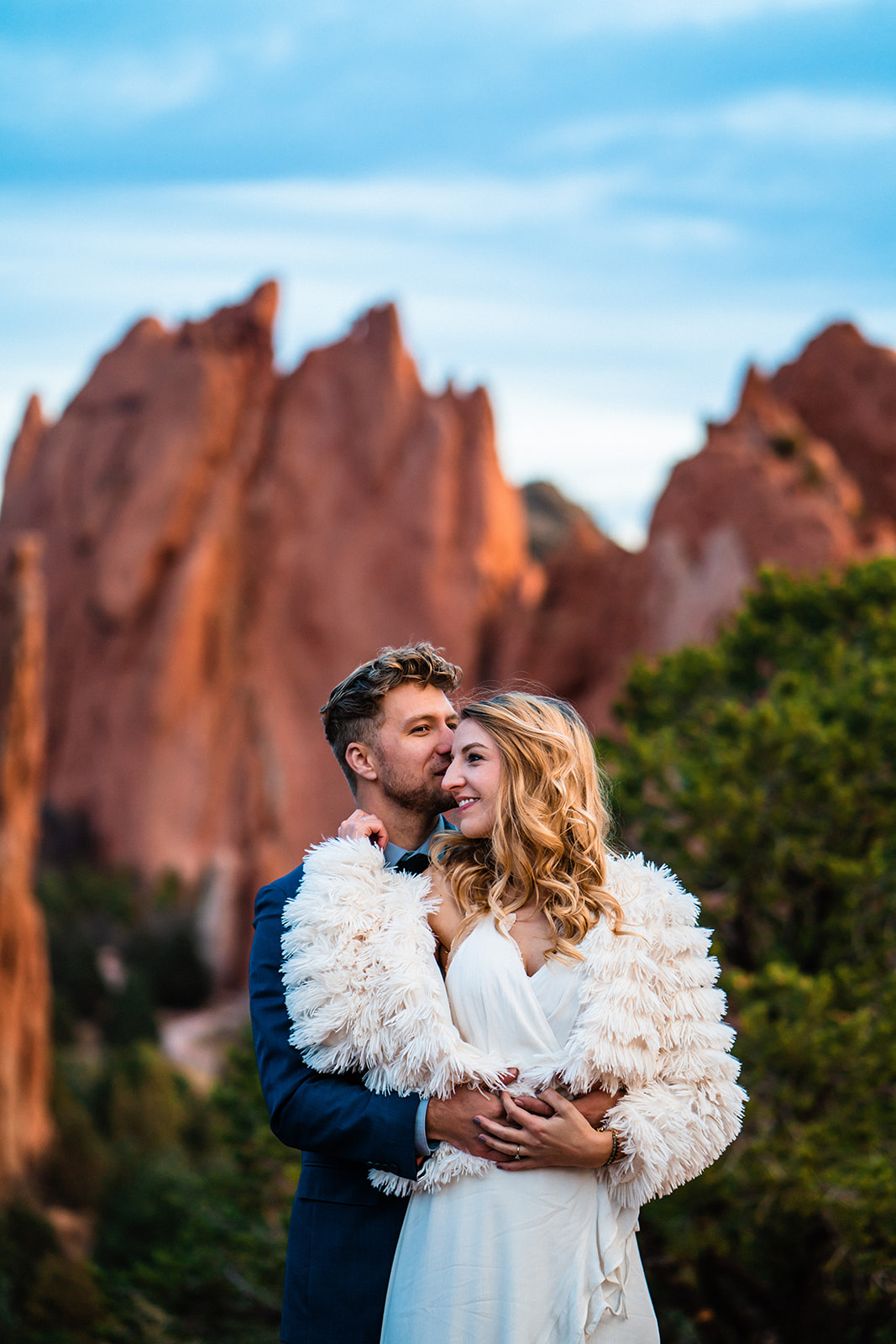 Engaged couple smiling and holding one another at the Garden of the Gods