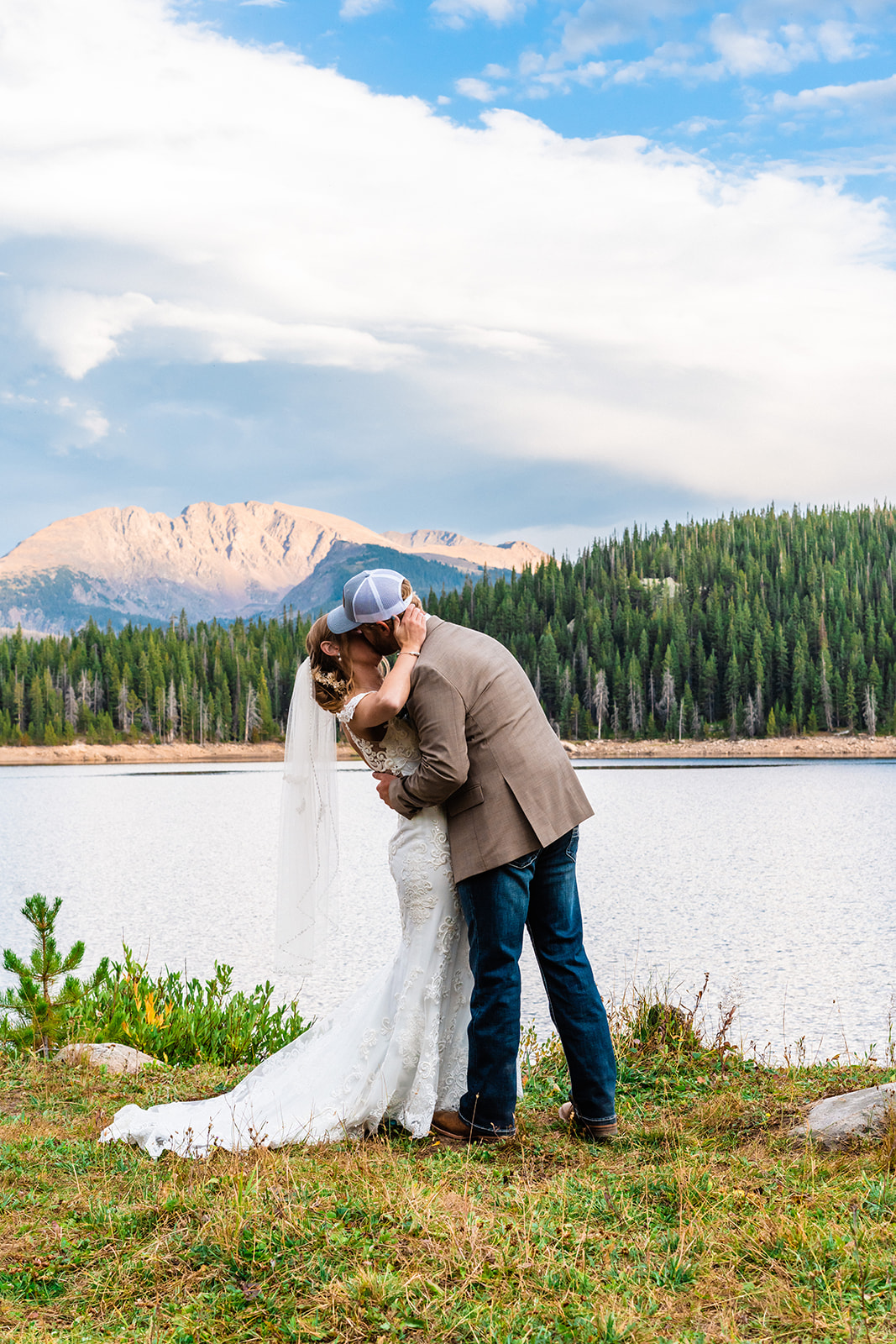 Bride and groom kissing with a High Alpine Lake in the background
