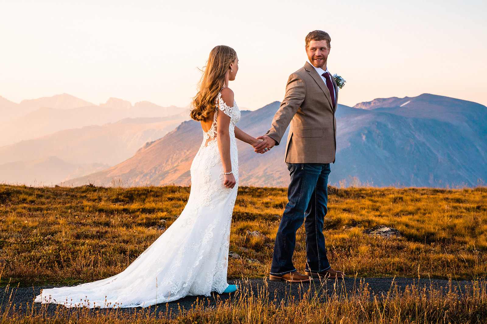 Bride and groom holding hands during sunrise