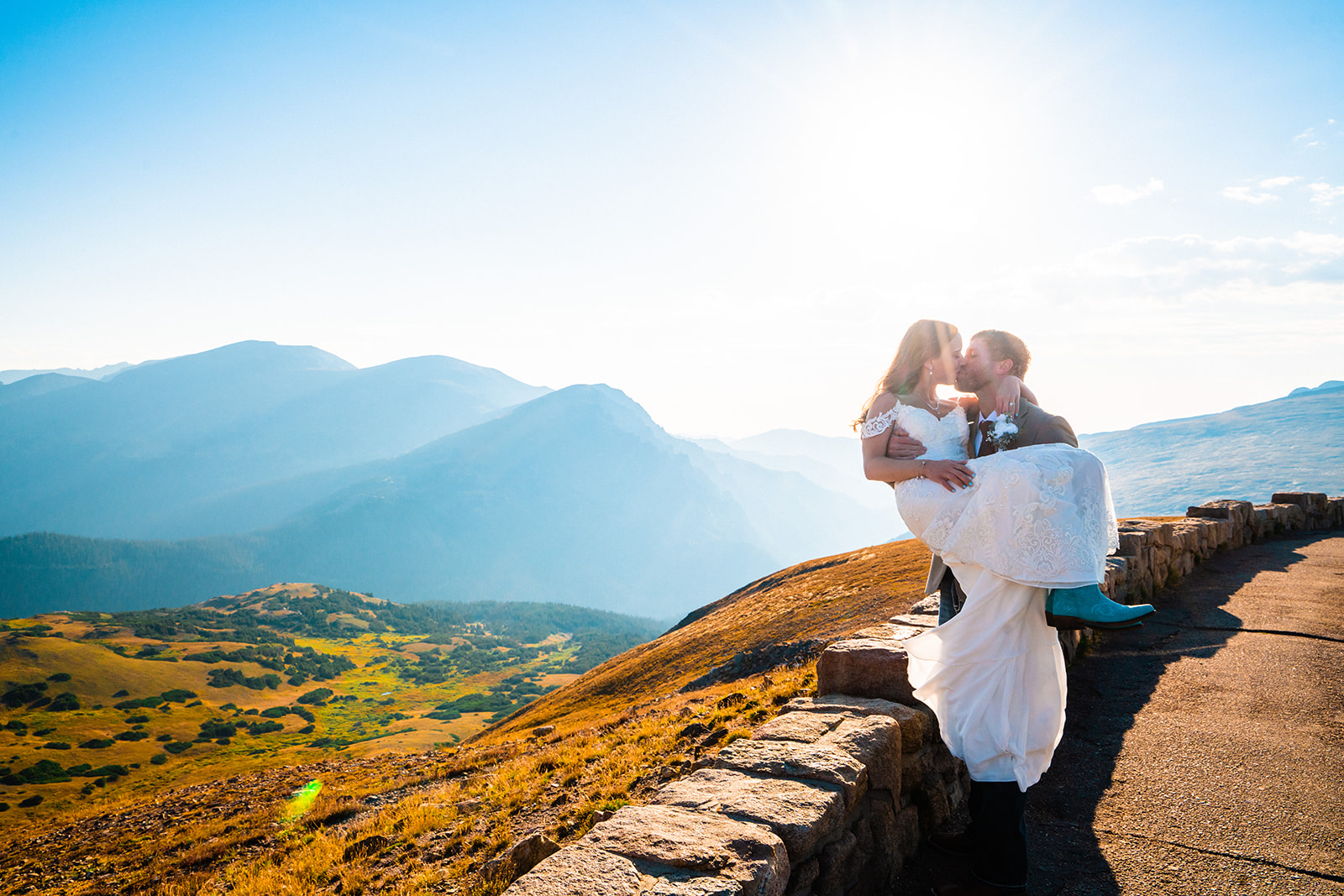 Bride and groom kissing during sunrise