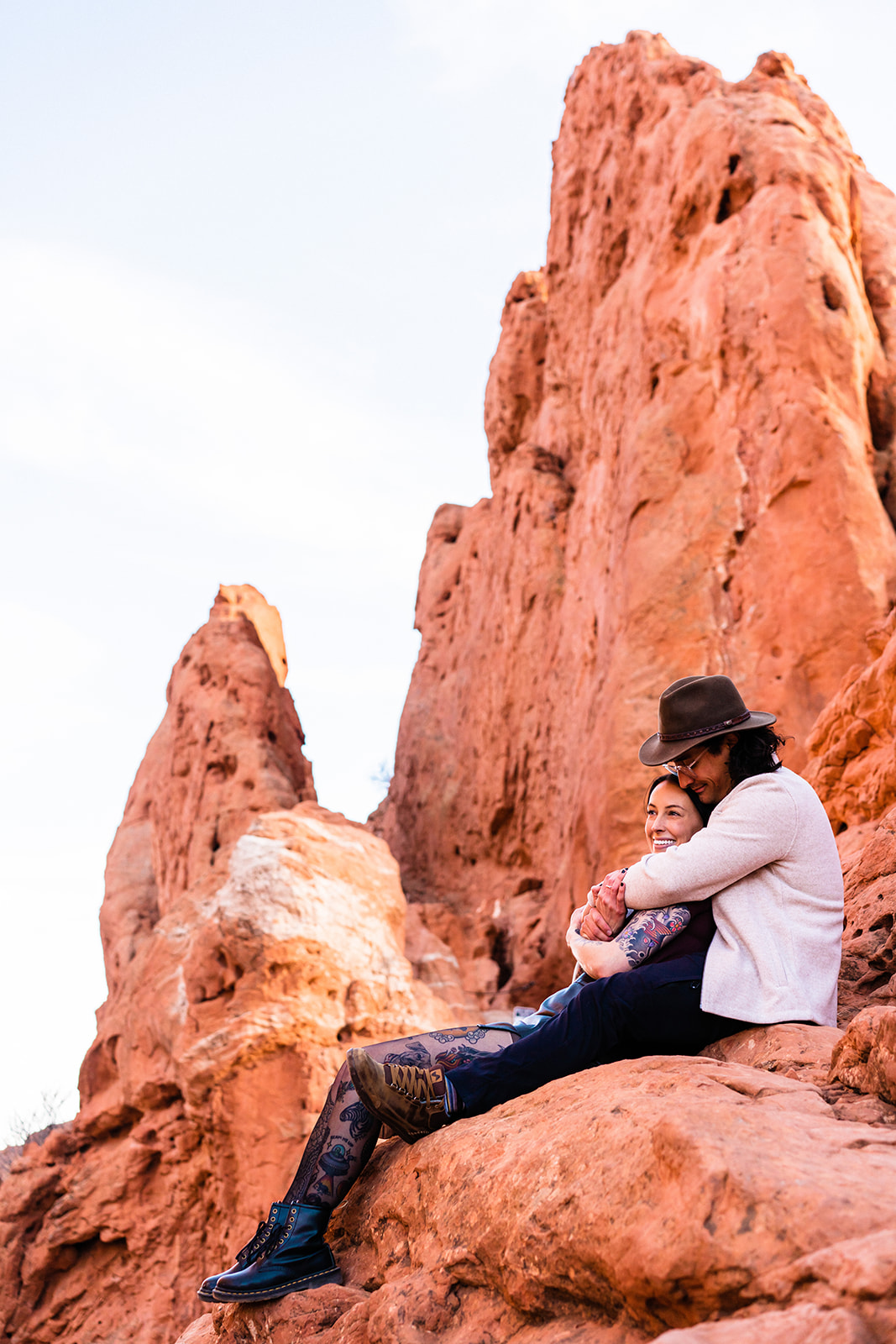 Newly engaged couple sitting on red rock formations