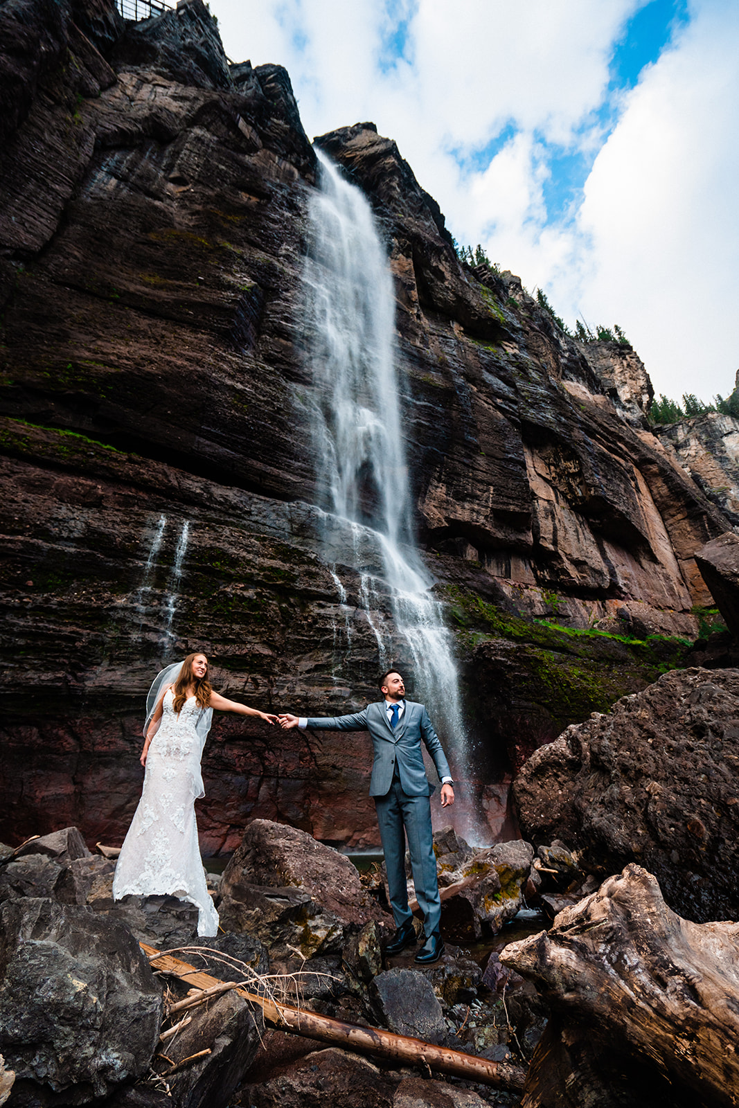 Bride and groom holding hands at Bridal Veil Falls
