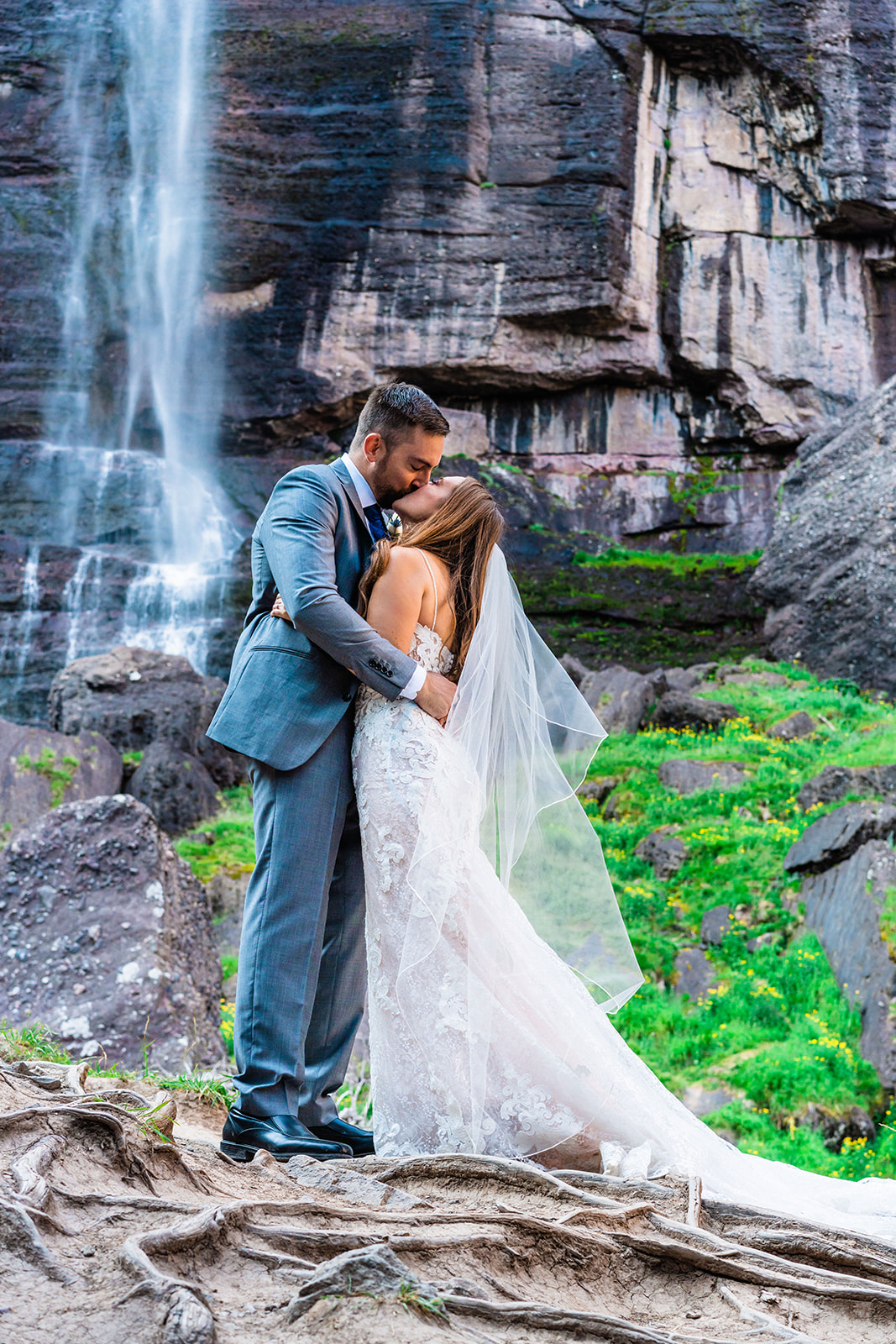 Bride and groom kissing in front of Bridal Veil Falls