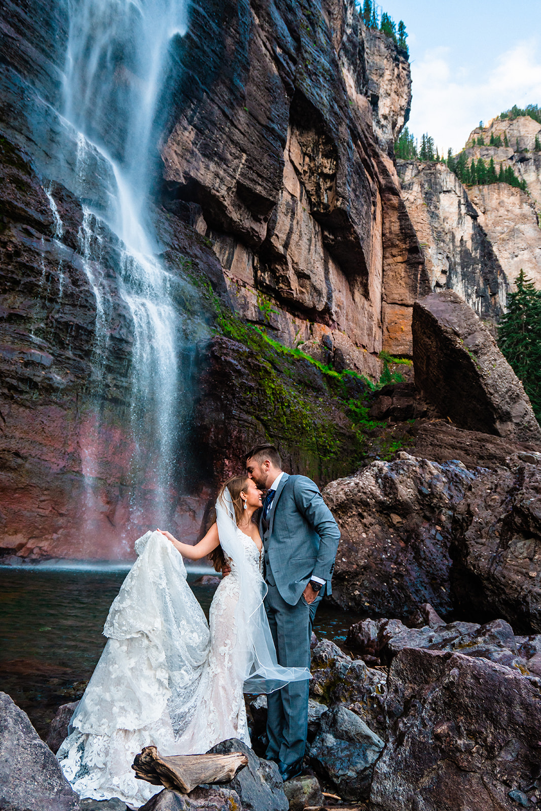 Bride and groom staring at one another endearingly in front of Bridal Veil Falls