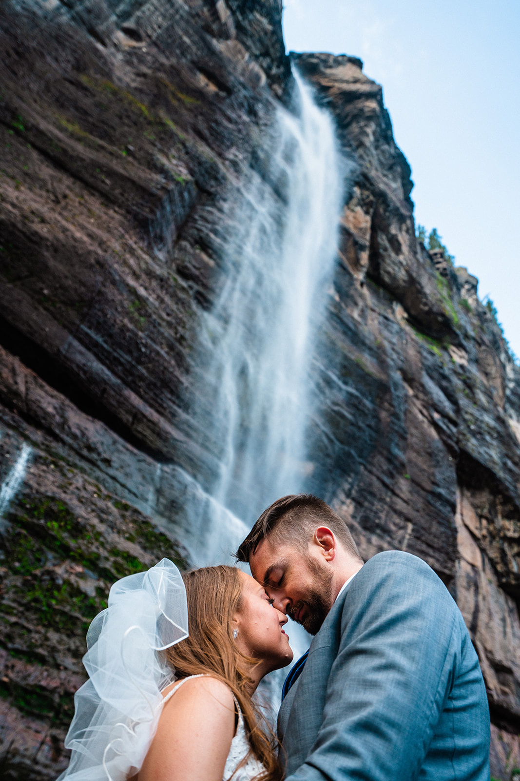 Bride and groom staring at one another endearingly in front of Bridal Veil Falls