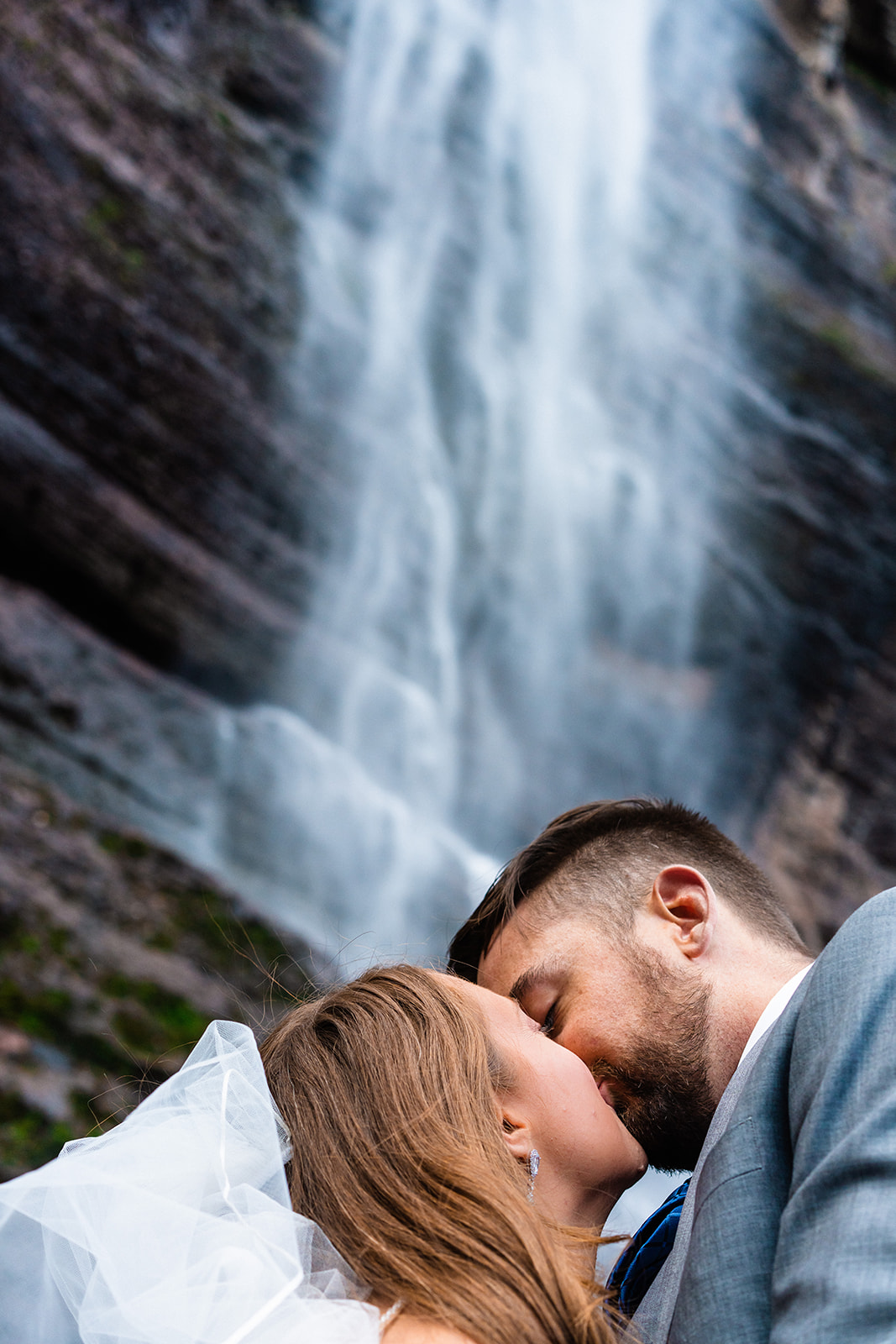 Bride and groom kissing under Bridal Veil Falls