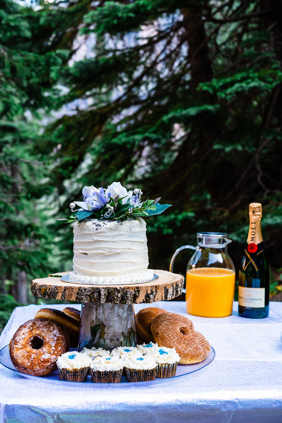 White floral elopement cake, donuts, and mimosas