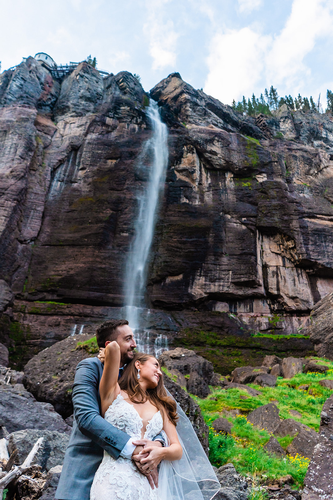 Beautiful adventurous bride and groom posing in front of Bridal Veil Falls in Colorado