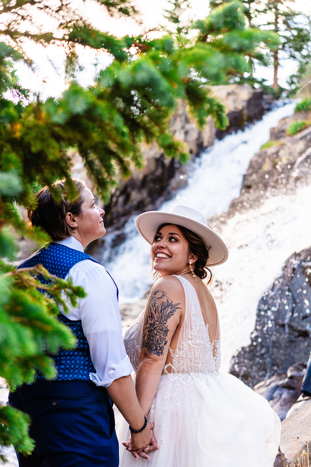 Bride smiling at her bride in front of a waterfall