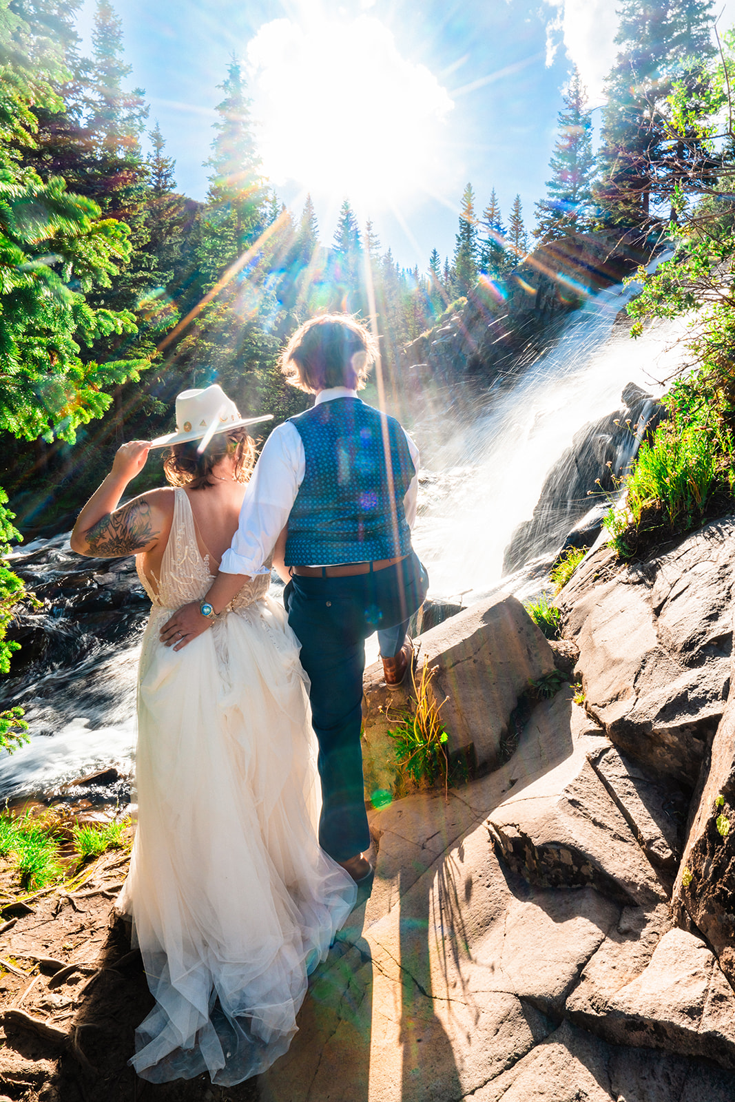 Adventurous lesbian couple standing in front of a waterfall