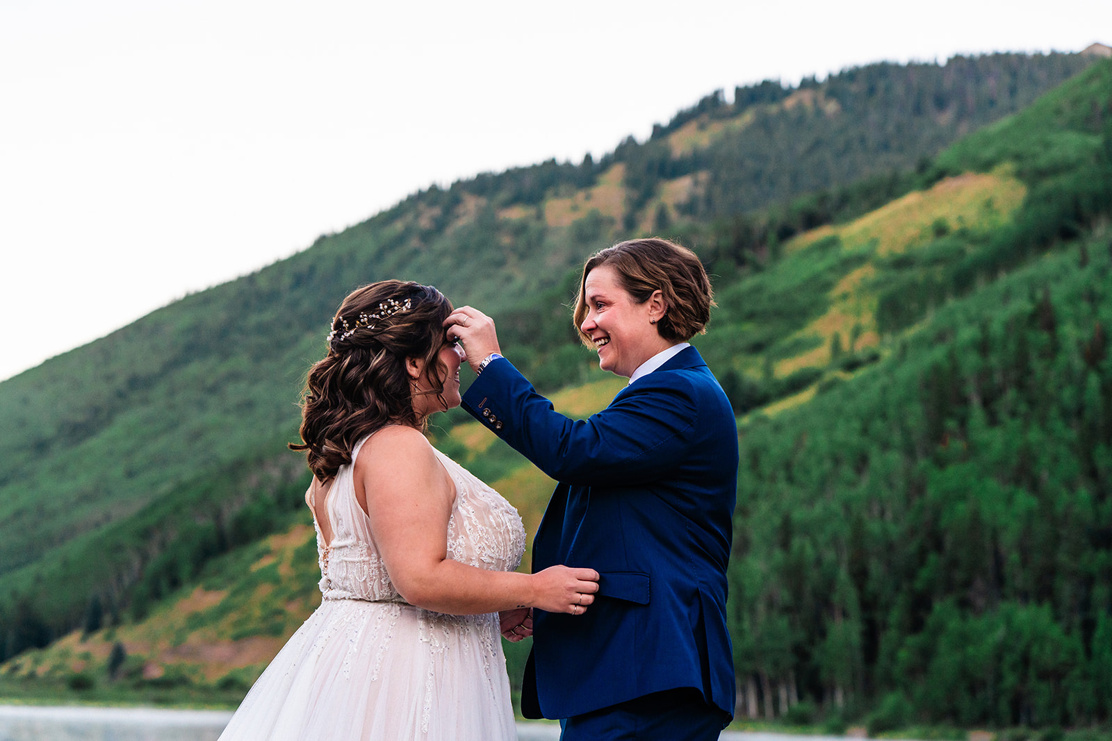 Lesbian couple standing in front of Colorado mountains for first look