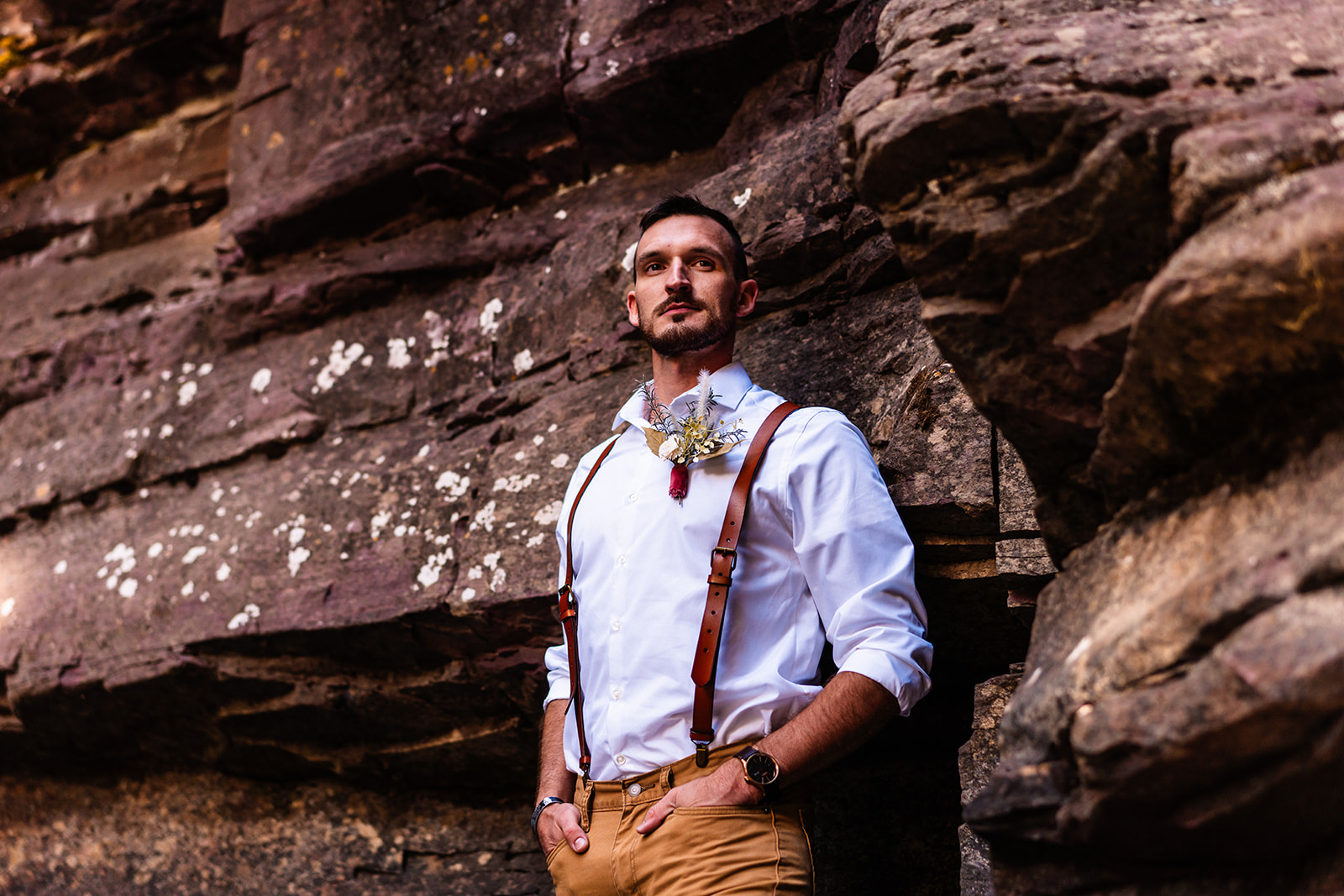 Groom posing in overalls and khakis in the San Juan Mountains